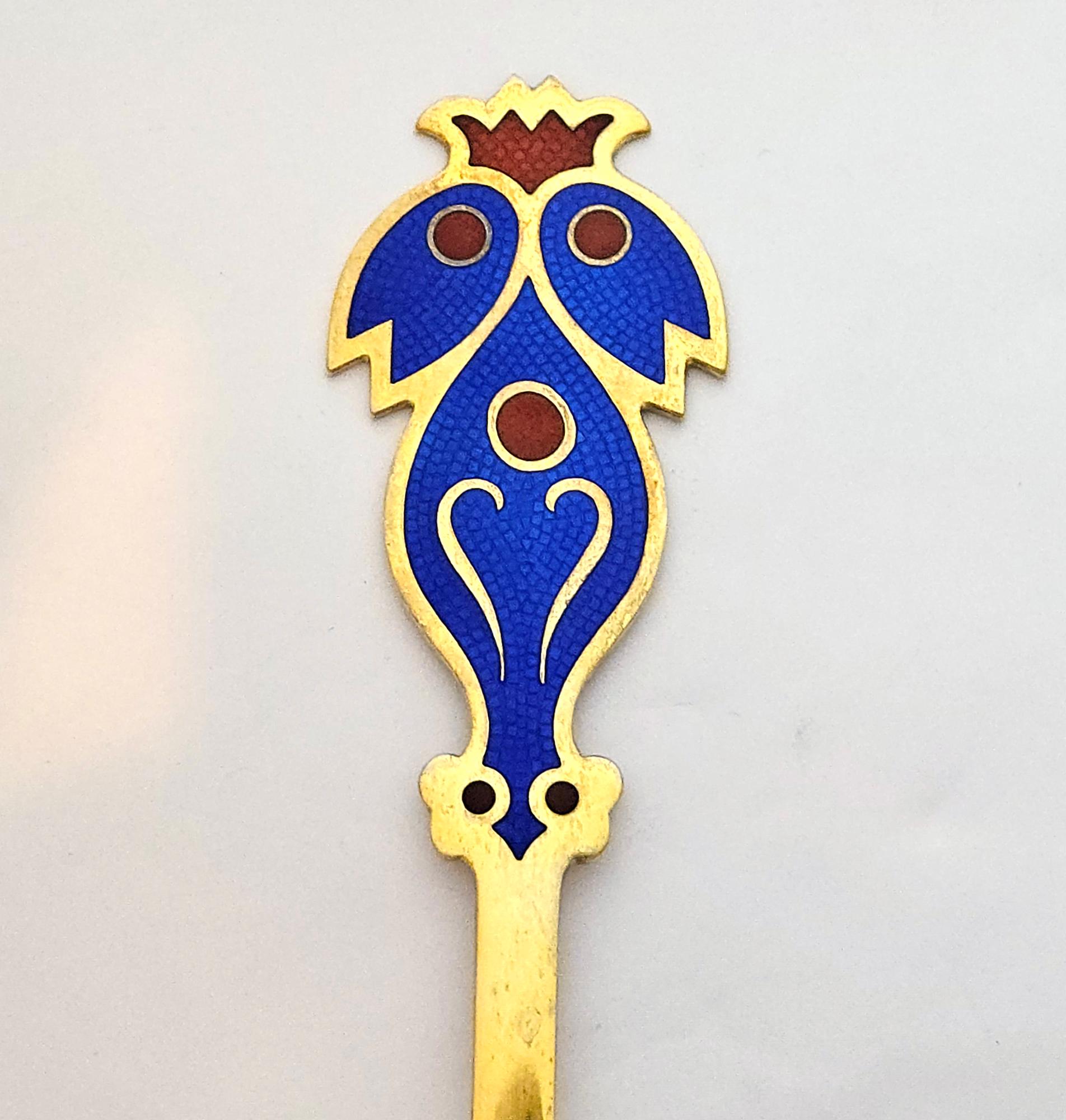 Cuillère de Noël en argent doré d'Anton Michelsen,
Carl-Henning Pedersen est le designer,
1974.

La cuillère en métal doré danois d'Anton Michelsen a été conçue par Carl Henning Pedersen.  La poignée est décorée en émail bleu d'un double oiseau
