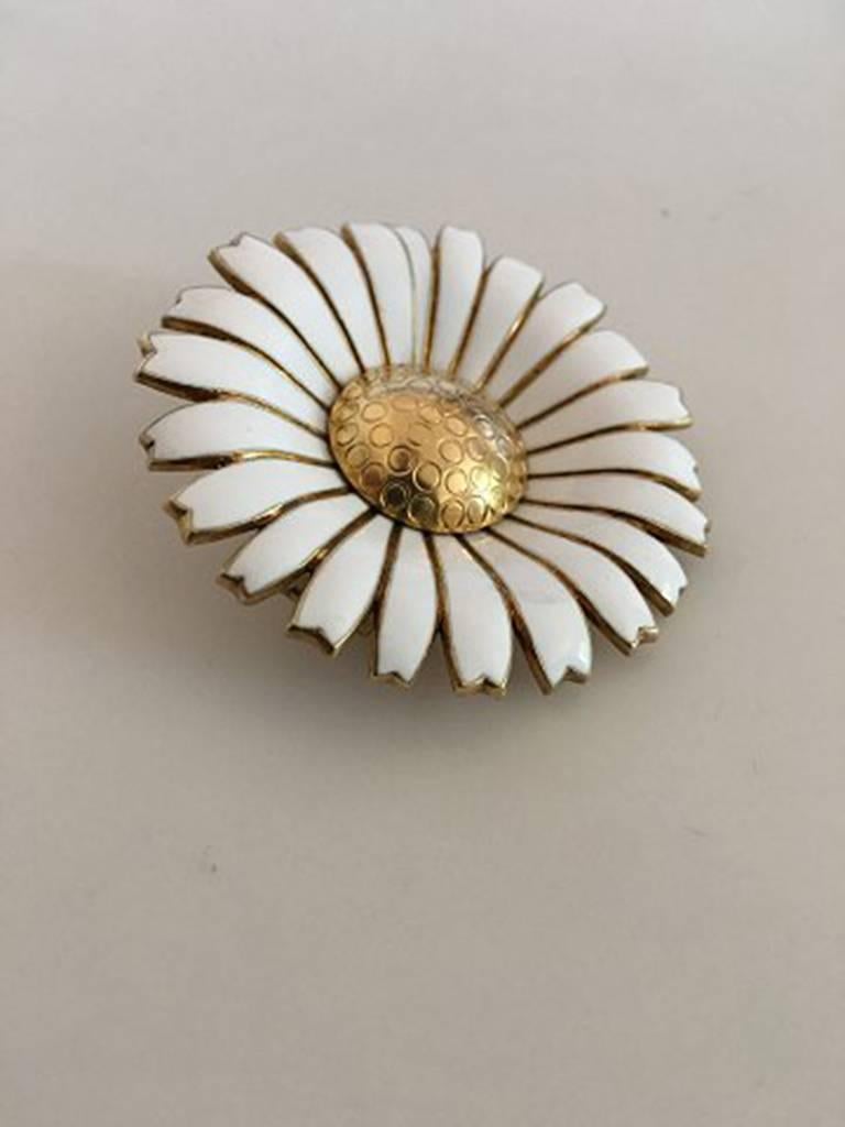 Anton Michelsen Daisy Brooch in Gilded Sterling Silver and White Enamel. Measures 5 cm / 1 31/32 in. Weighs 31.2 g / 1.10 oz. In nice condition