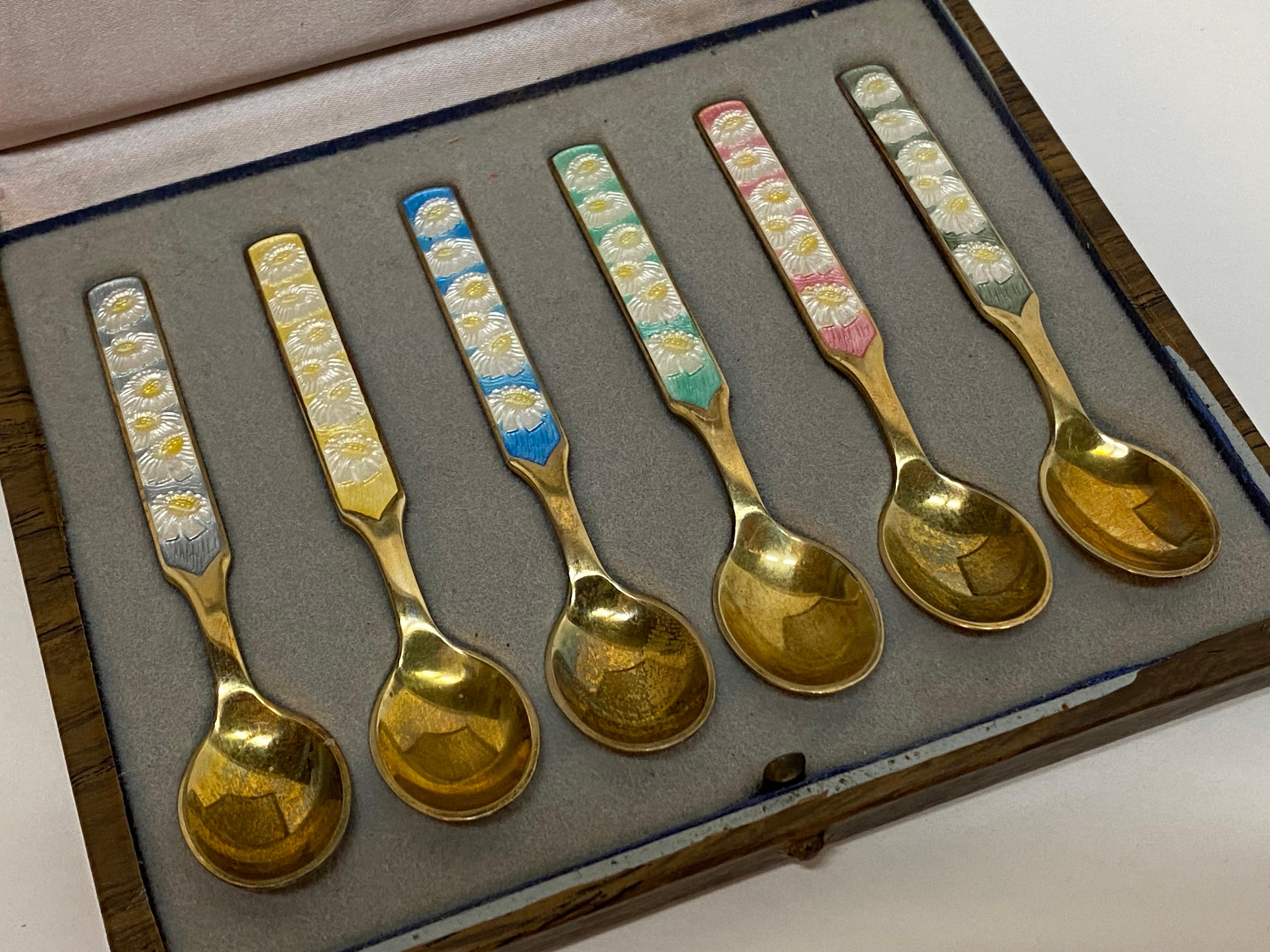 Set of six enameled sterling silver demitasse spoons complete with box. Signed Anton Michelsen, Sterling, Danmark. Circa 1950. Six spoons with enameled floral handles. Good overall condition and possibly never been used. Some tarnish. No visible