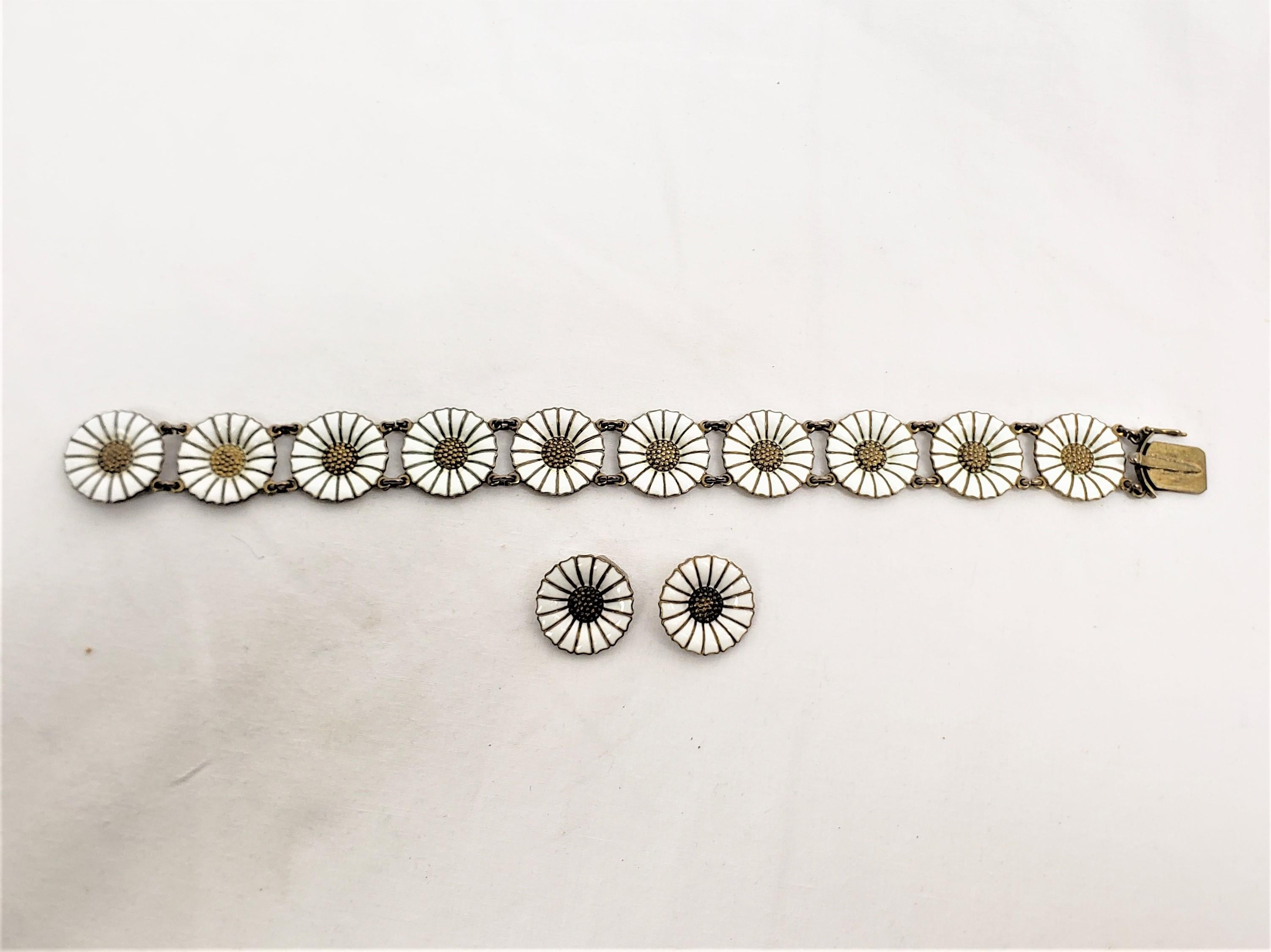 Dieses Armband und Ohrring-Set wurde von dem bekannten dänischen Designer Anton Michelsen um 1960 im Stil der Jahrhundertmitte gefertigt. Das Armband und die Ohrringe bestehen aus Sterlingsilber und haben die Form von stilisierten Gänseblümchen mit