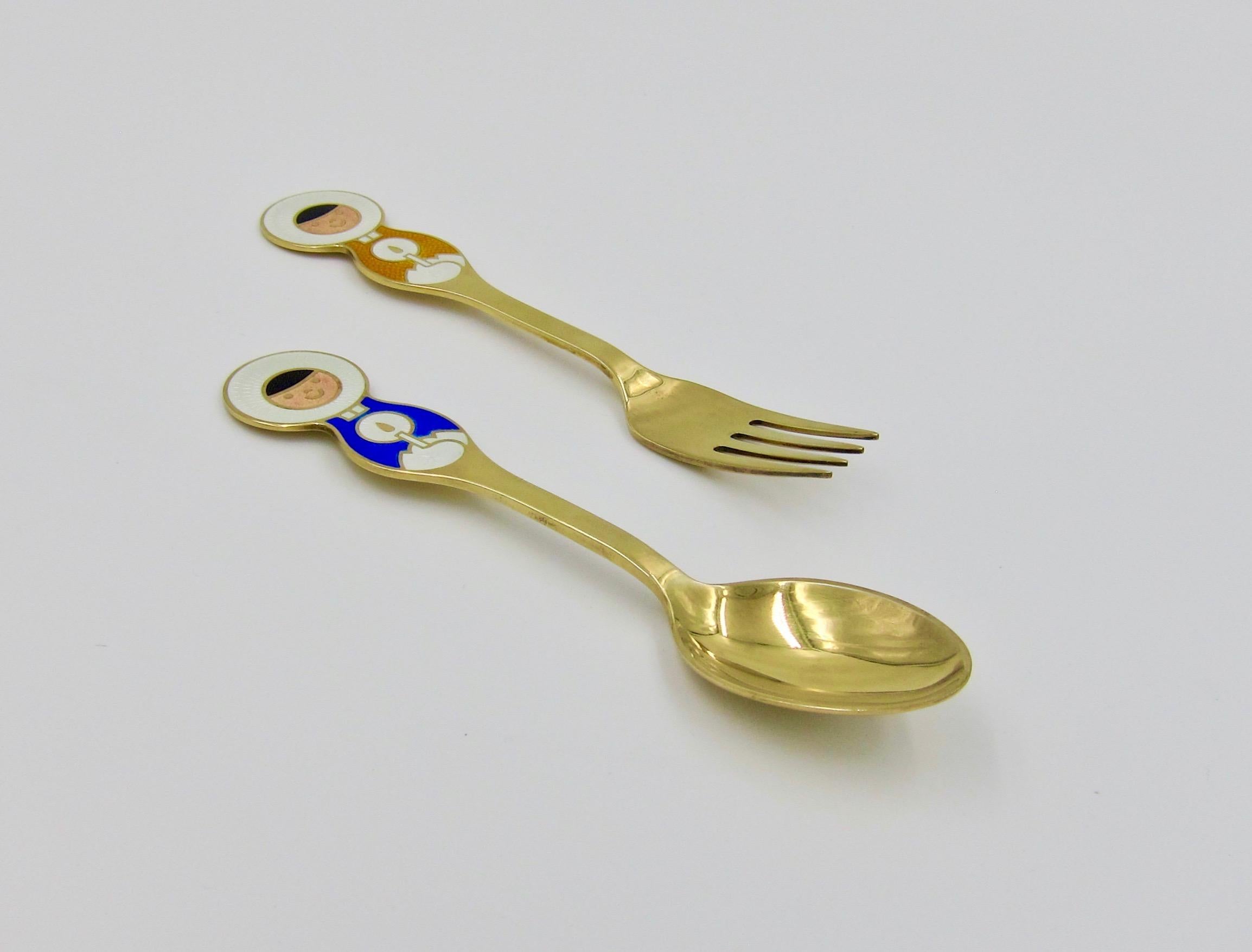 A Danish gilt sterling silver and enamel Christmas fork and spoon set from Anton Michelsen of Copenhagen, Denmark. Artist Ib Antoni (1929-1973) created this 