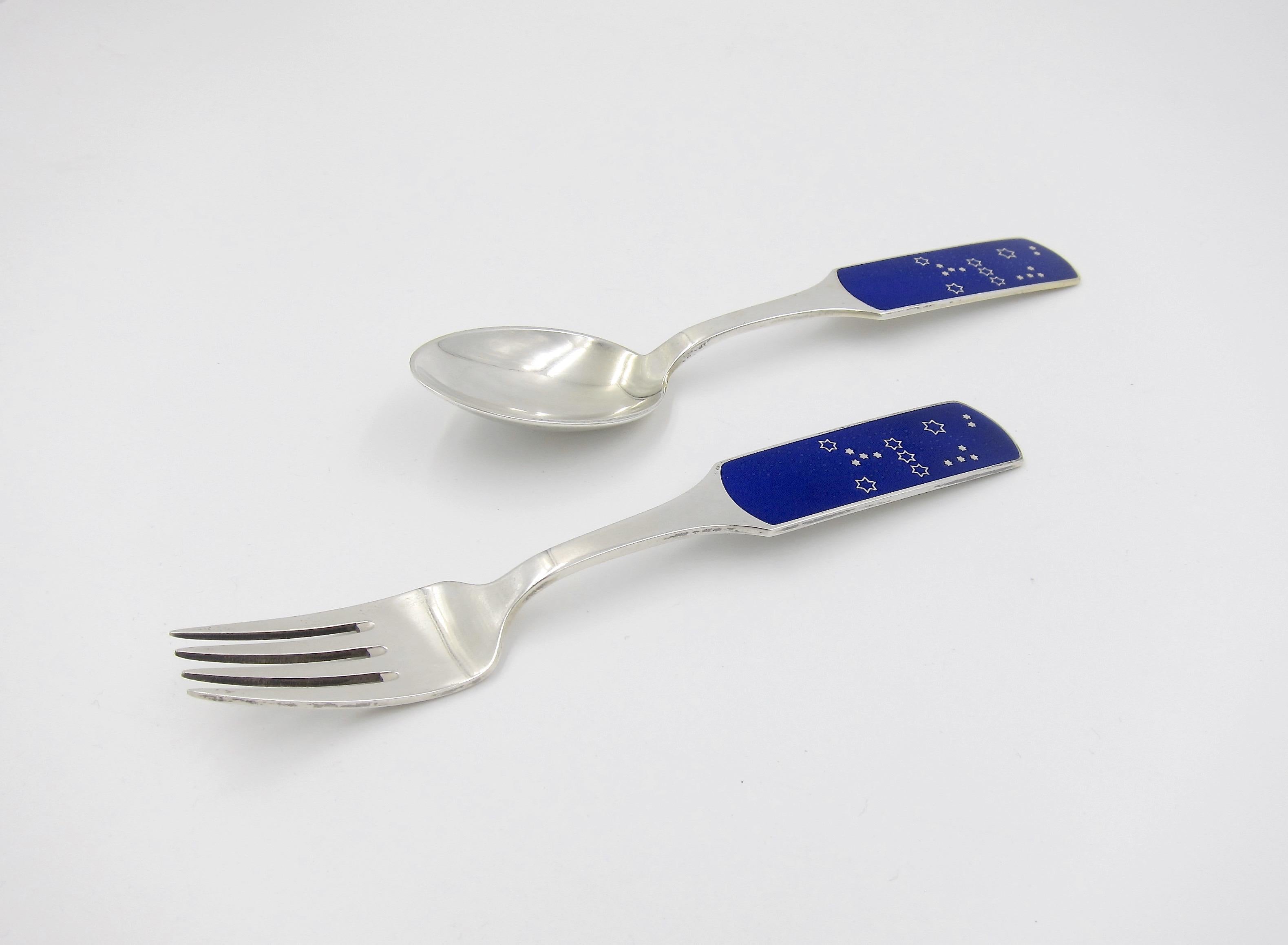A Danish sterling silver and enamel Christmas fork and spoon set from Anton Michelsen of Copenhagen, Denmark. Artist Inger Hanmann (1918-2007) created this design called 