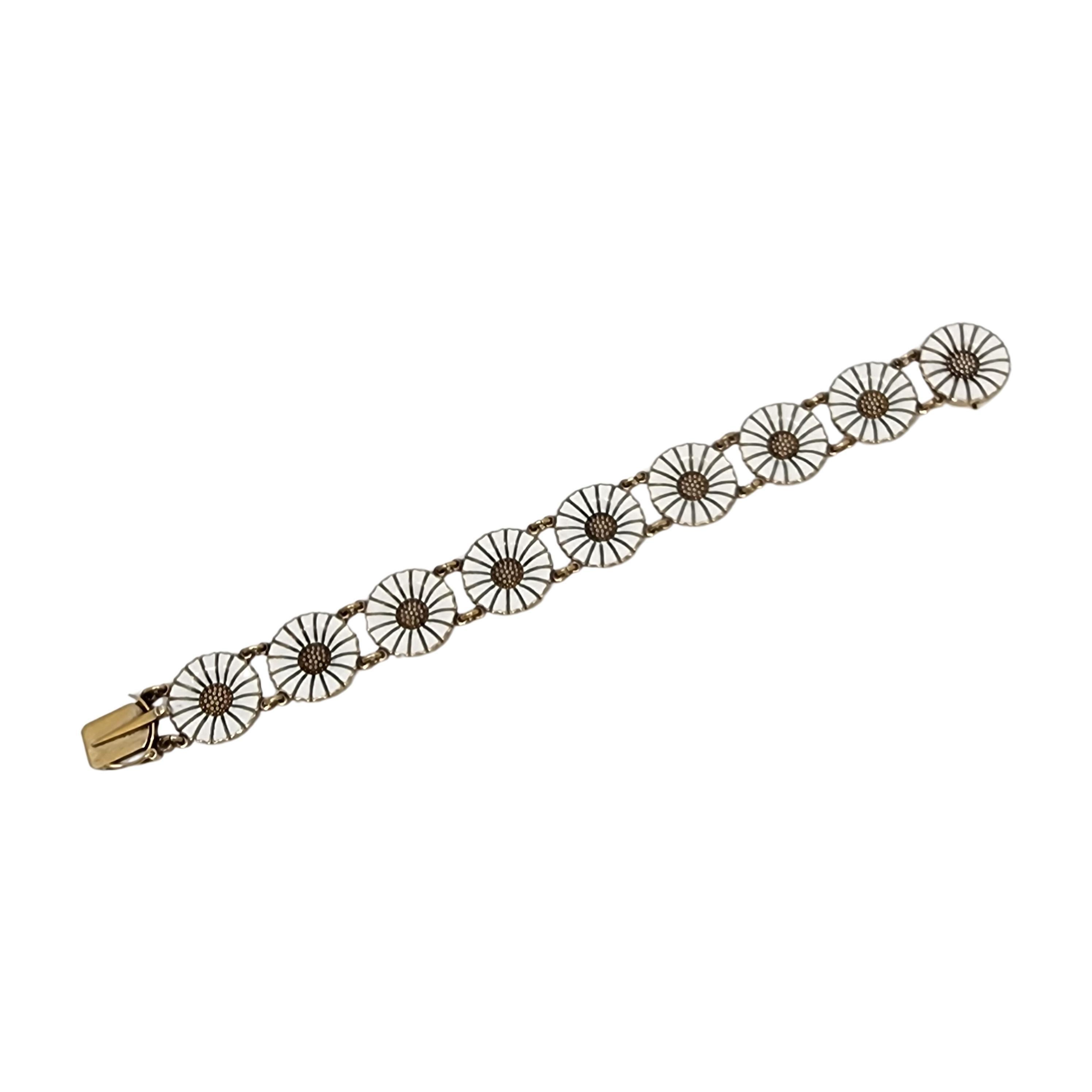 Vintage sterling silver gold wash and enamel Marguerite Daisy bracelet by Anton Michelsen of Denmark.

A gold tone over sterling silver link bracelet featuring white enamel Marguerite Daisies, the National flower of Denmark. Slide closure with