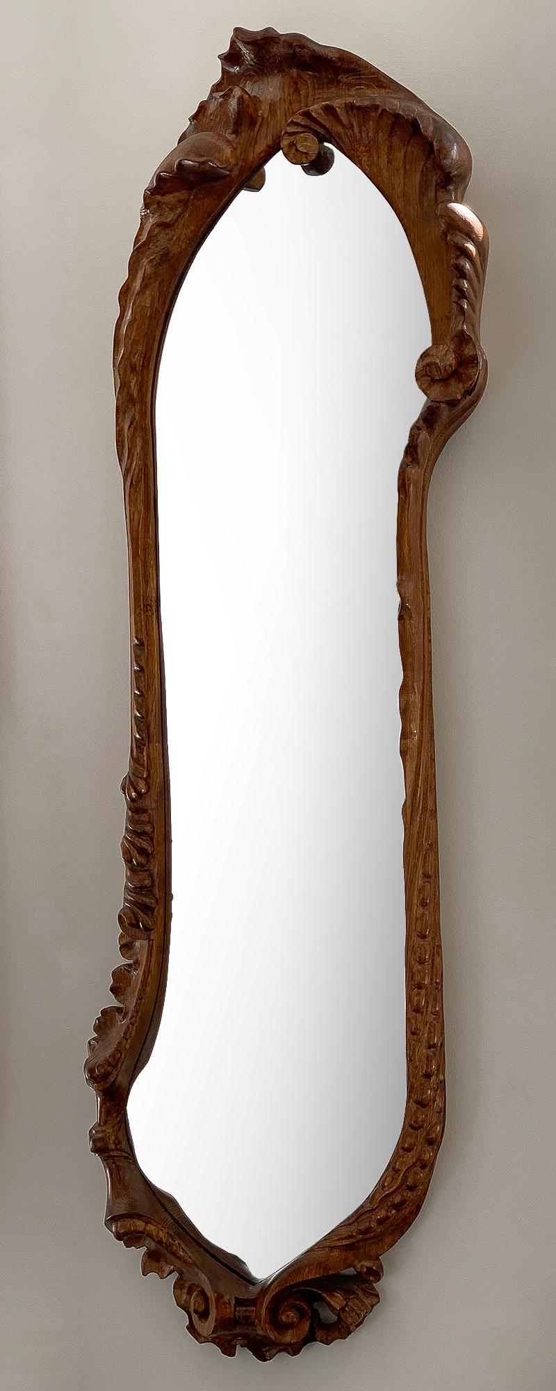 Antoni Gaudí Calvet wall mirror in oak. Designed by Gaudí in 1902 for the Casa Calvet and reissued by BD Furntiure, Barcelona. Carved solid oak with varnished finish. The Art Nouveau style ornately carved asymmetrical wall mirror features a