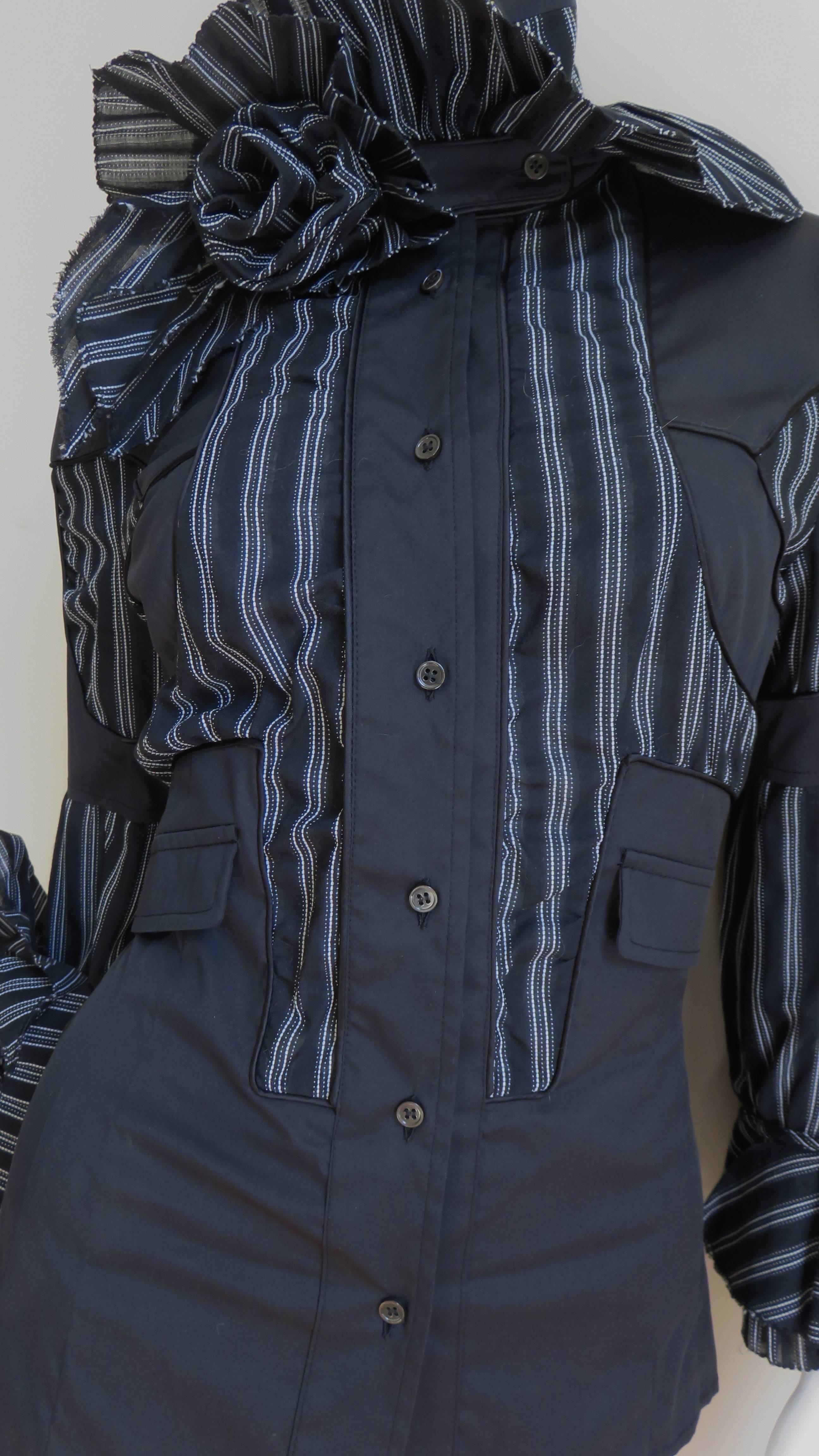 A gorgeous shirt or jacket from Antonio Berardi in solid black and black with white stripes silk cotton blend with a bit of stretch. It has lots of details- fabric roses and ruffles at the neck and wrists, a buttoned stand up collar, pockets at the