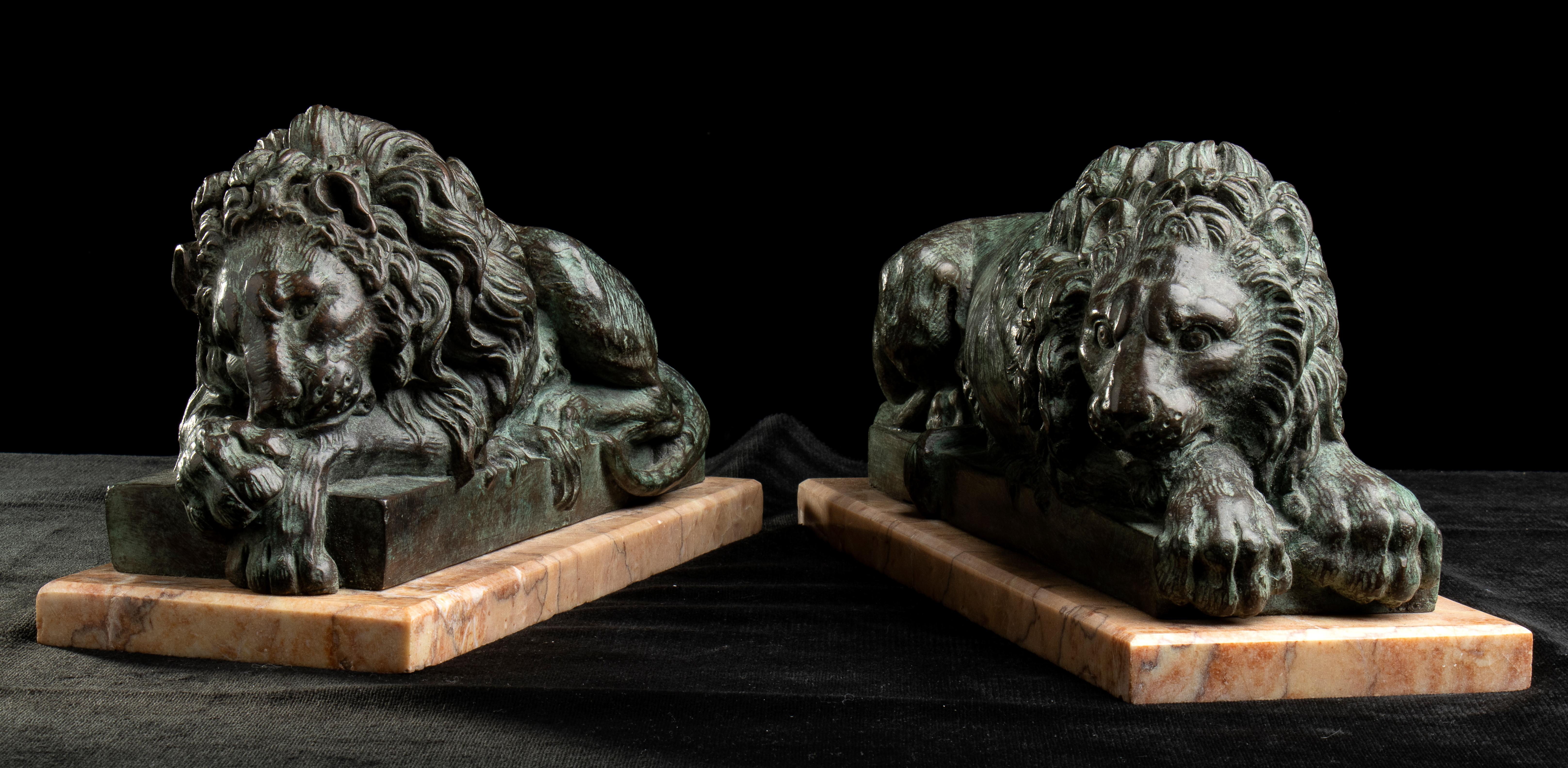 Une paire impressionnante et importante de sculptures de grand tour de lions à la manière d'Antonio Canova, sculptées en bronze et reposant sur une base en marbre. L'œuvre, représentant un lion endormi, en corrélation avec l'autre lion, cette fois