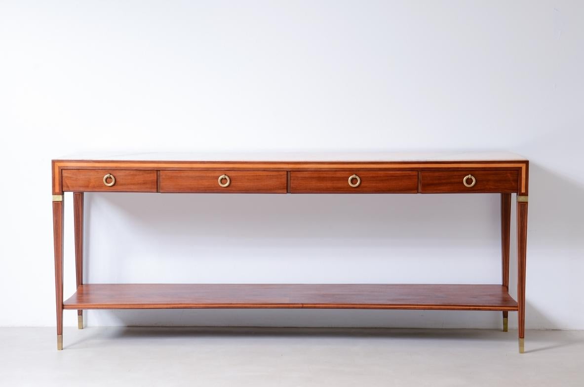 
COD-2841
Antonio Cassi Ramelli (1905-1980)

Consola grande con tapa de mármol de Portugal. Adornos roscados de madera clara de estilo clásico y elegantes detalles de latón, 4 cajones y encimera perfilada.

Arquitecto y profesor milanés, Cassi