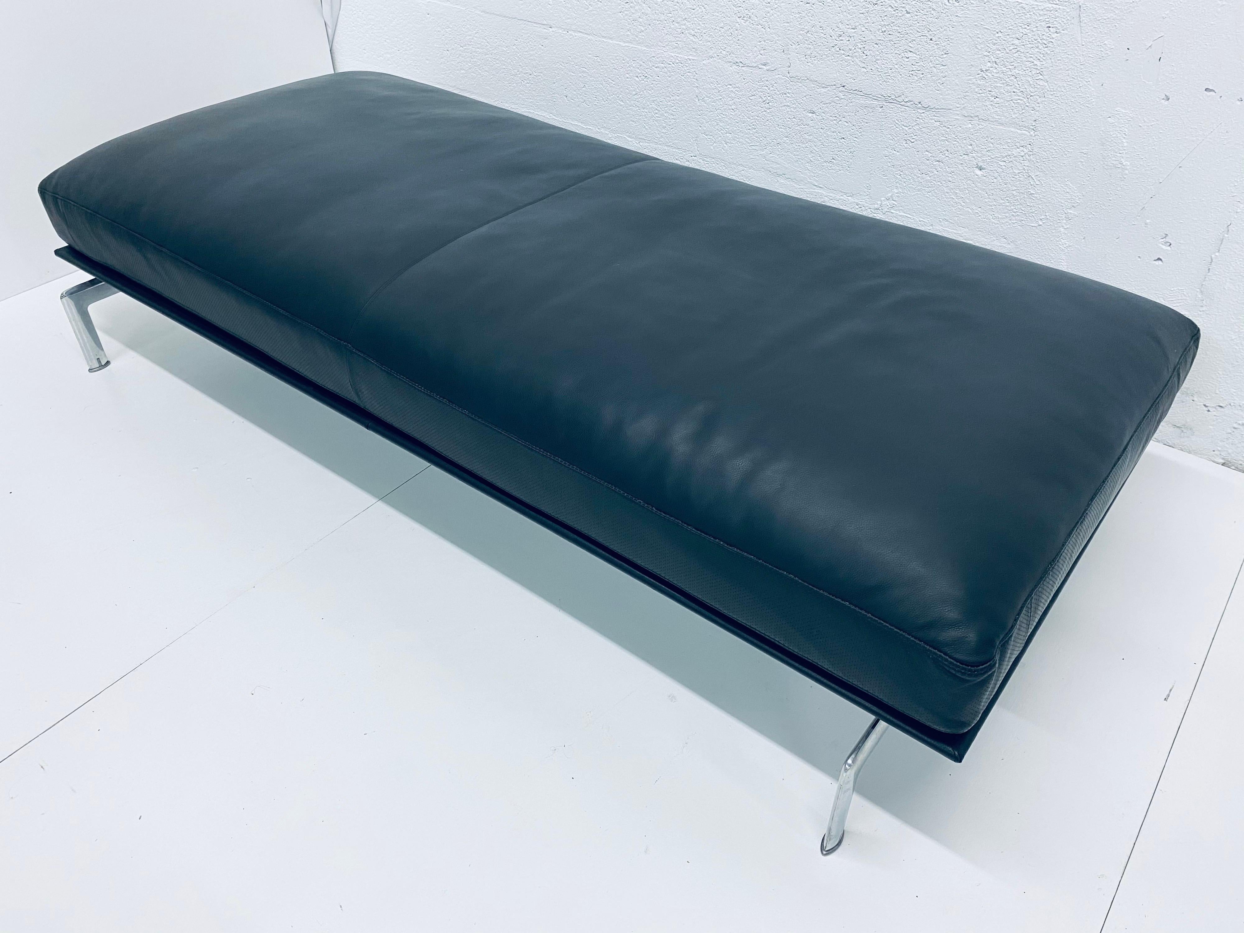 Designed by Antonio Citterio and Paolo Nava for B&B Italia, the Diesis bench is made with a black leather upholstered cushion with soft down filling and sits on a large leather wrapped steel base and chrome legs. Handcrafted and extremely
