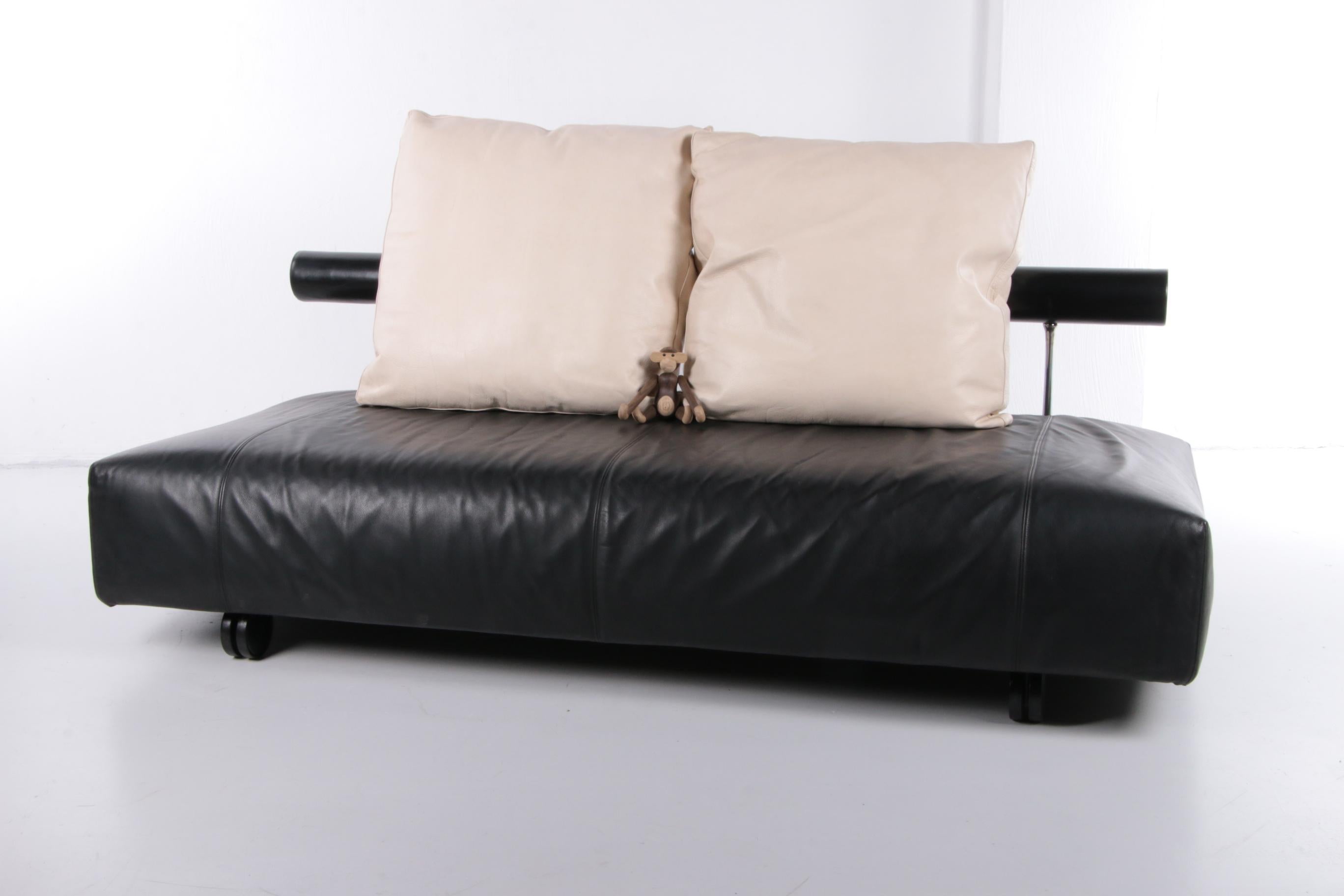Beautiful quality sofa made of black and white leather. It has an interesting design with the minimalist backrest and the thick, comfortable cushions.

A brand is engraved on the back of the sofa. The brand can also be found on the back of the