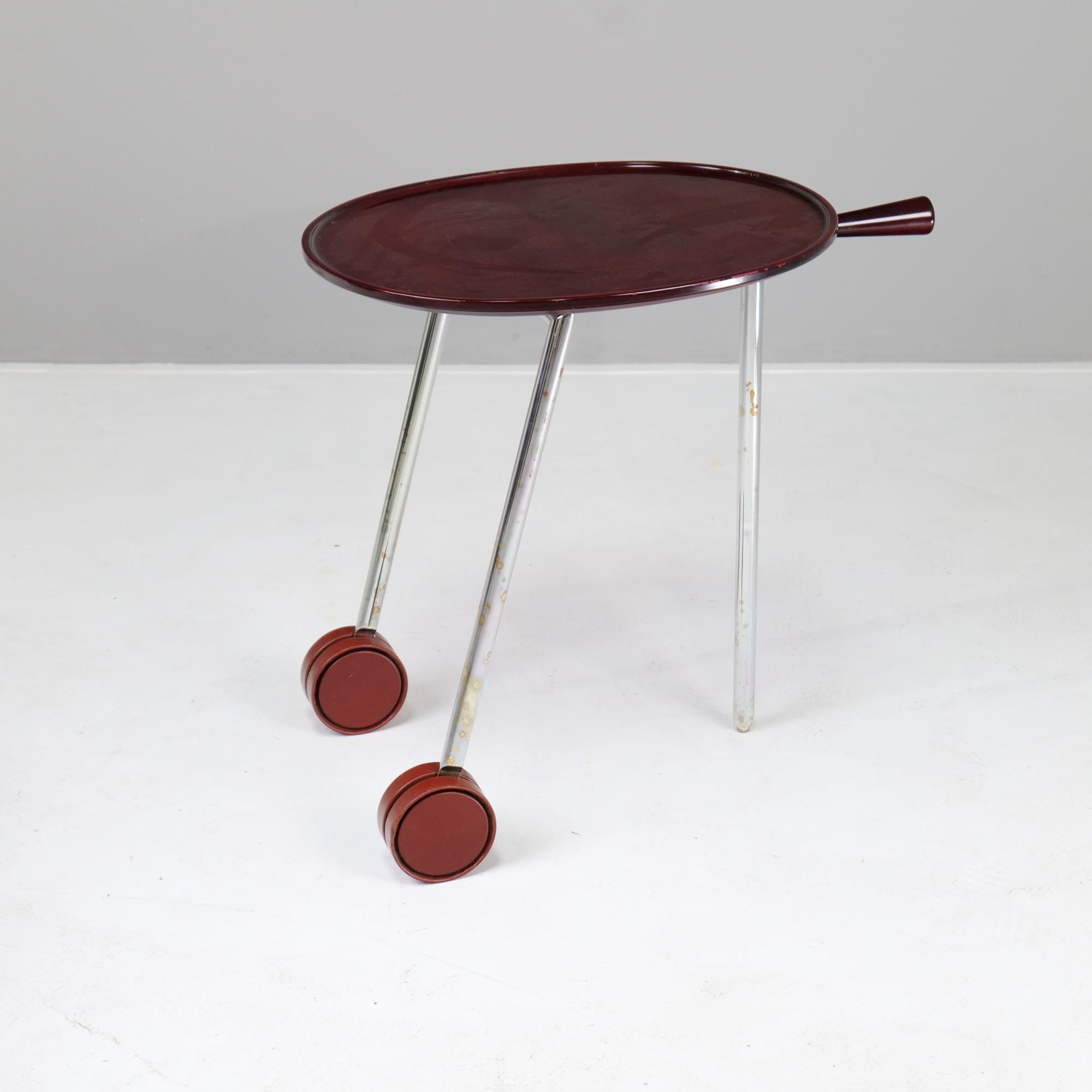 Antonio Citterio designed a small side table on castors with a Bordeaux red lacquered oval top.

The table can be moved by means of a handle.