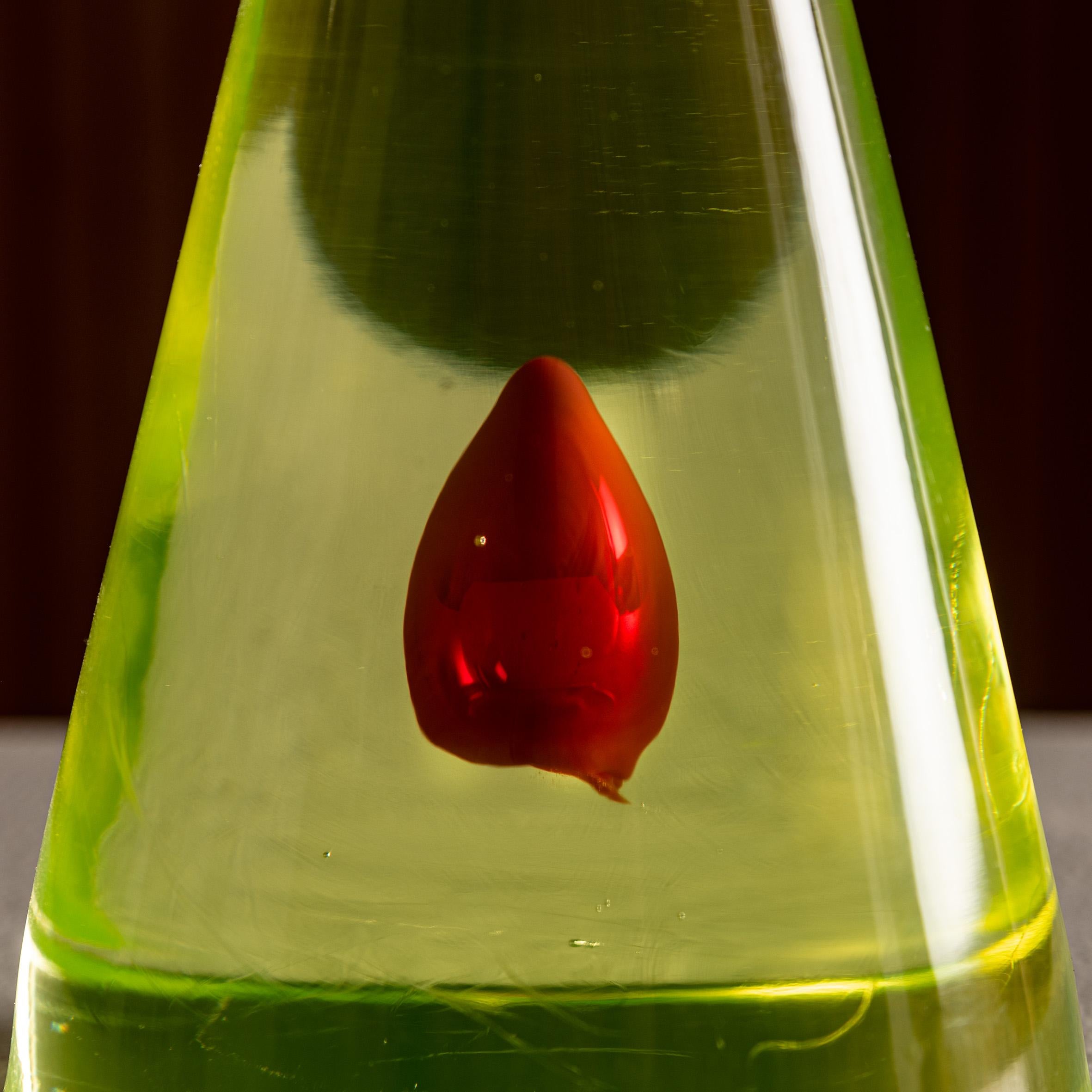 Exceptional Murano glass cone sculpture, attributed to Antonio Da Ros for Seguso Vetri d’Arte, circa 1960. This striking work is executed in uranium glass, with a vivid green conical body encasing a suspended red sommerso drop at its center. The