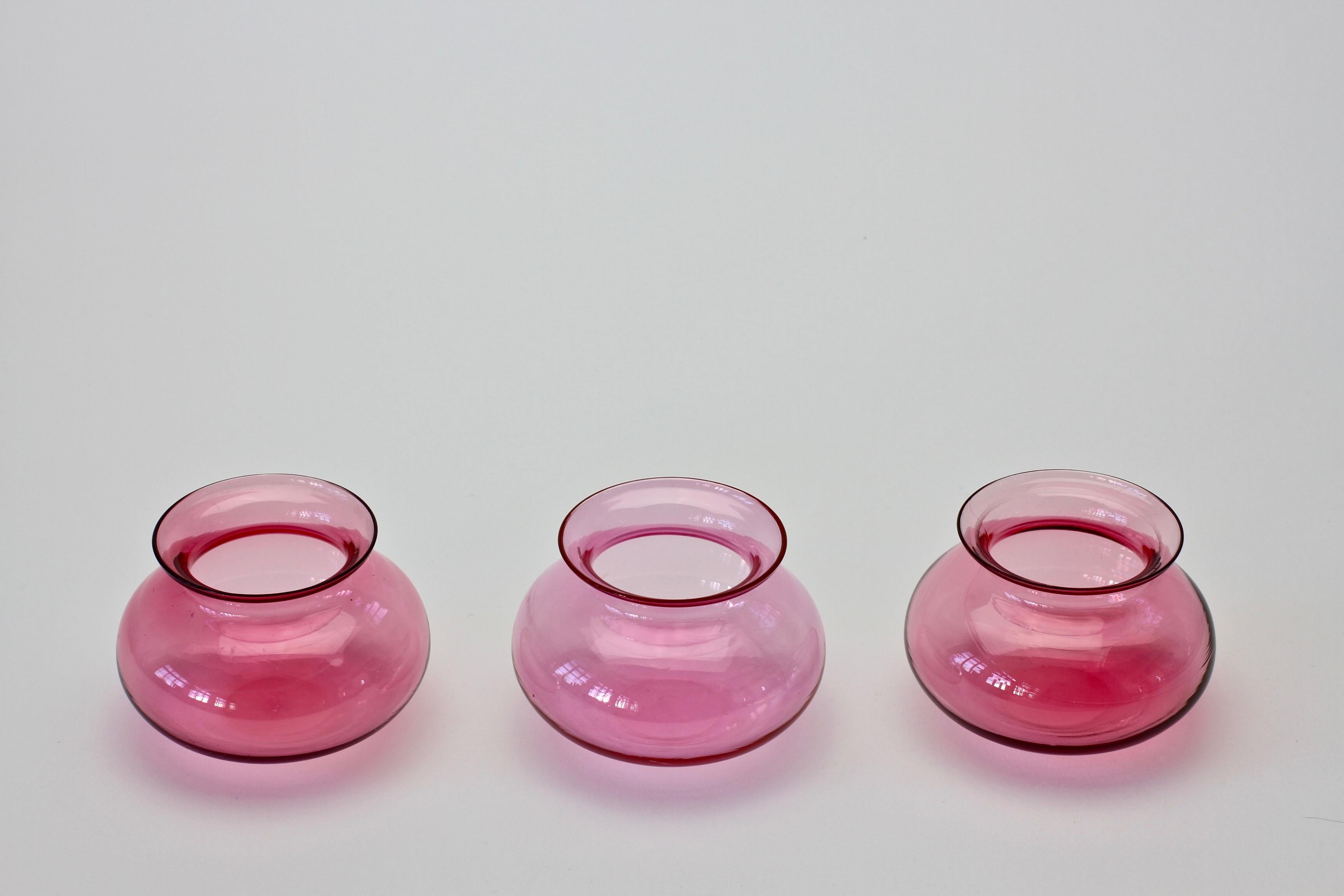 Set or trio of three vibrant pink Murano glass vases. Wonderful translucent pink color (color). Simplistic yet elegant form. 

Vases measure approximately 5.6cm tall by 8.5cm in diameter. 

  