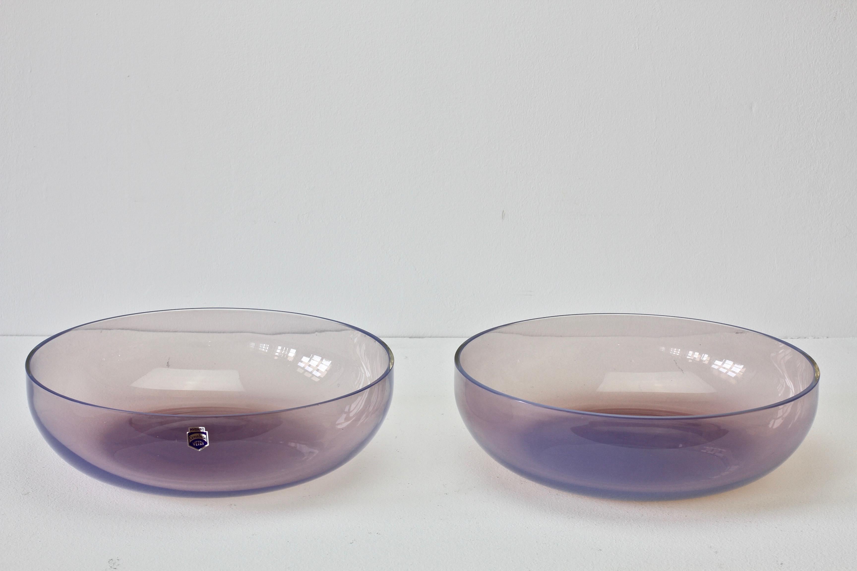 Large pair of pink / aubergine colored 'Opalino' Murano glass serving / center bowls designed by Antonio da Ros (1936-2012) for Cenedese, circa 1970-1990. Wonderful translucent color of pink or aubergine, almost pink sapphire to purple amethyst.