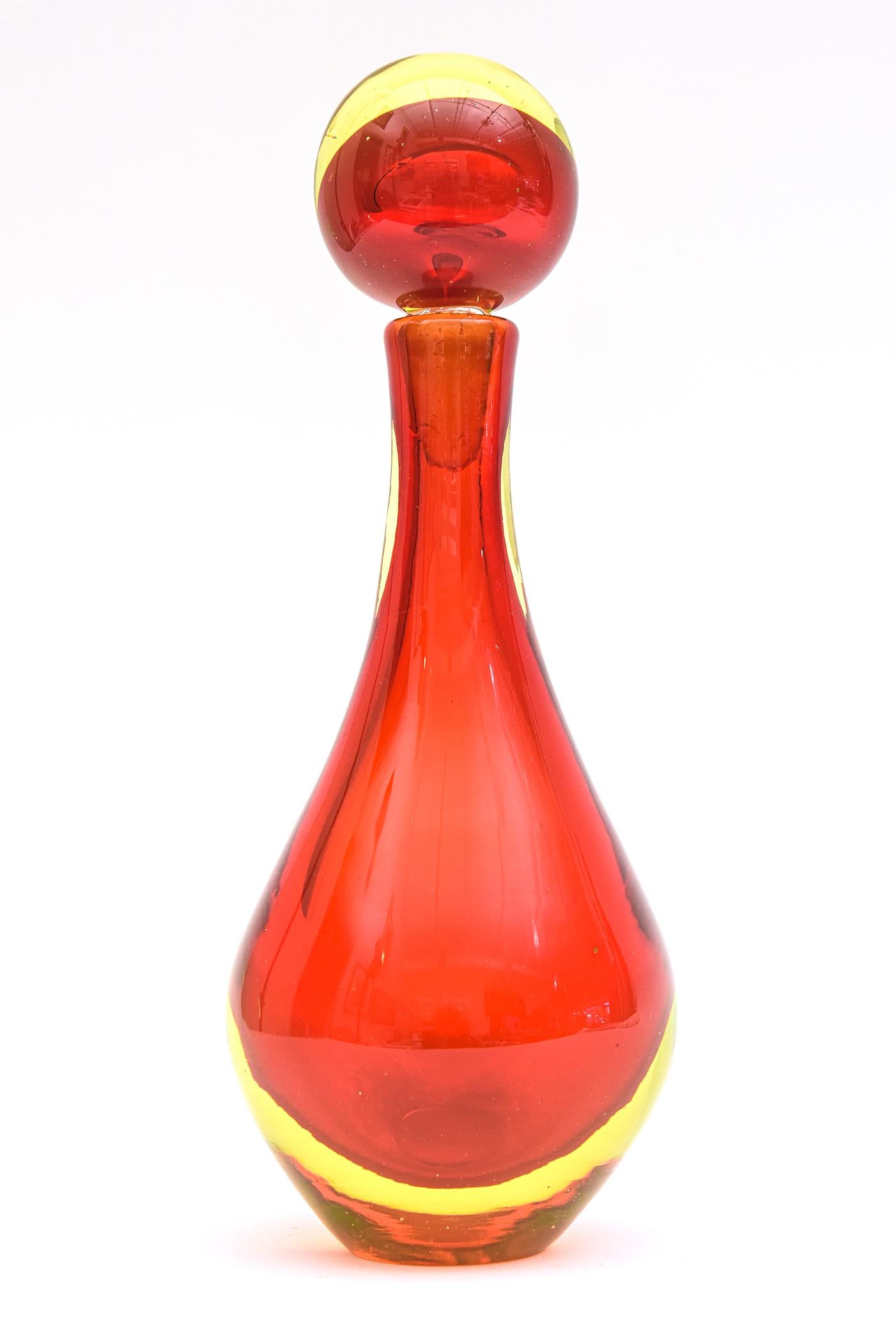 This stunning and brilliant vintage Italian Murano hand blown sommerso decanter or perfume bottle is by Antonio da Ros for Cenedese. It is from the 60's. The colors of red and yellow in sommerso juxtapose each other in great contrast. The bulblous
