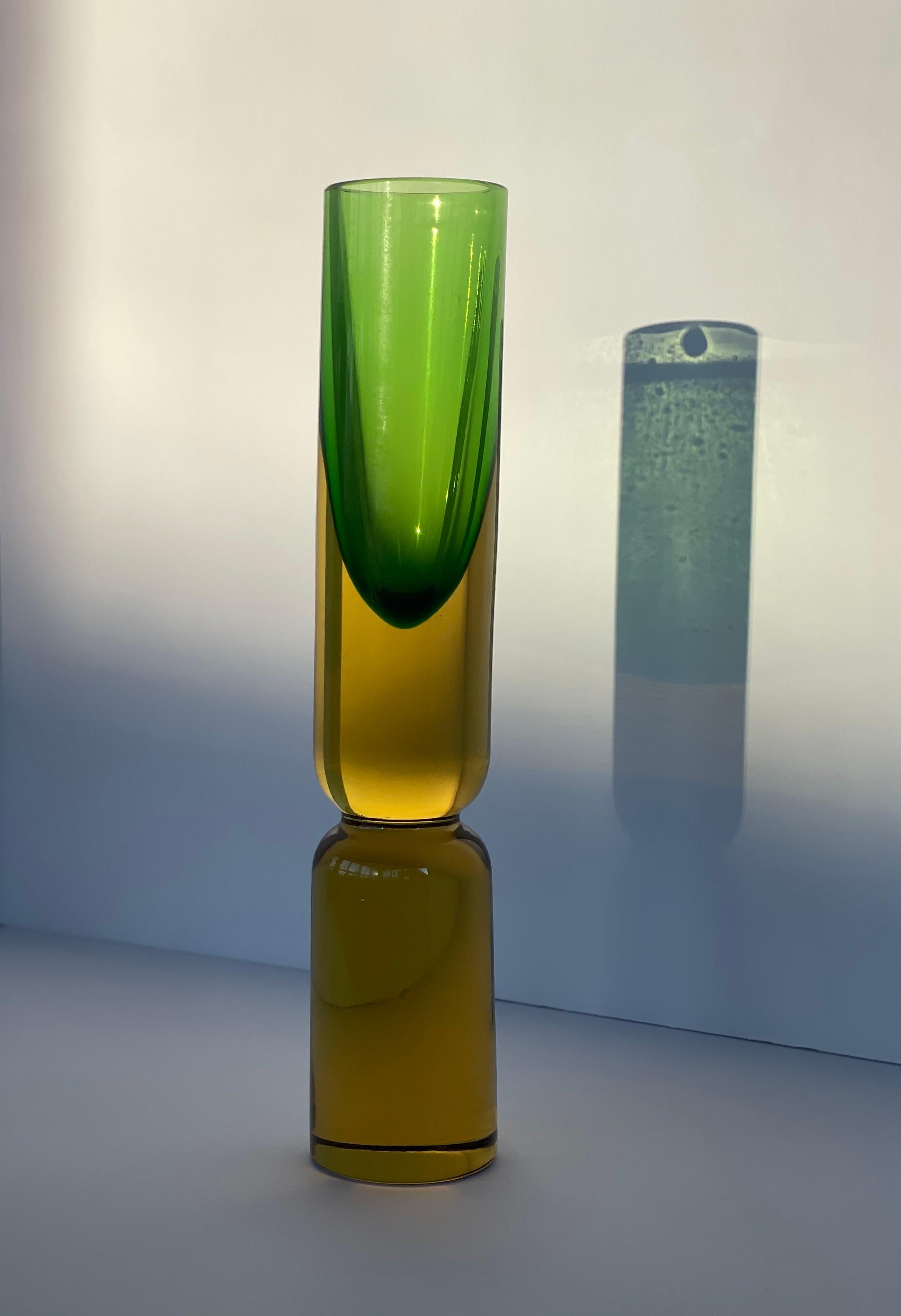 Uno splendido vaso in vetro di Murano della metà del secolo scorso, disegnato da Antonio Da Ros per Cenedese, Italia, circa 1950. Questo vaso cilindrico alto è uno squisito esempio della tecnica del Sommerso (vetro sommerso), con un nucleo verde