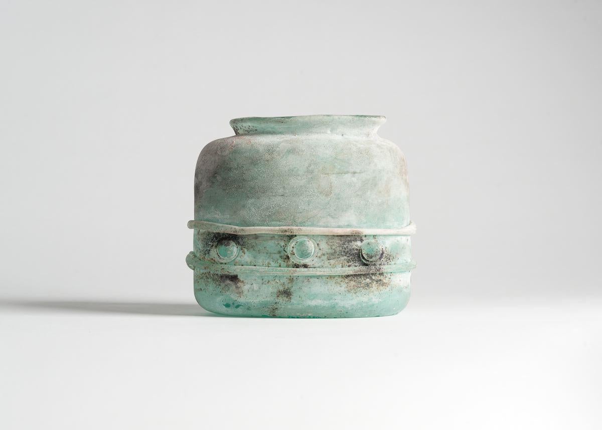 Made in 1983 by Antonio Da Ros for Vetreria Gino Cenedese, this near opaque,
turquoise vase possesses an elegant simplicity of form, and features an
abstract, geometric relief that encircles its base. It was made with the rare
scavo technique, by