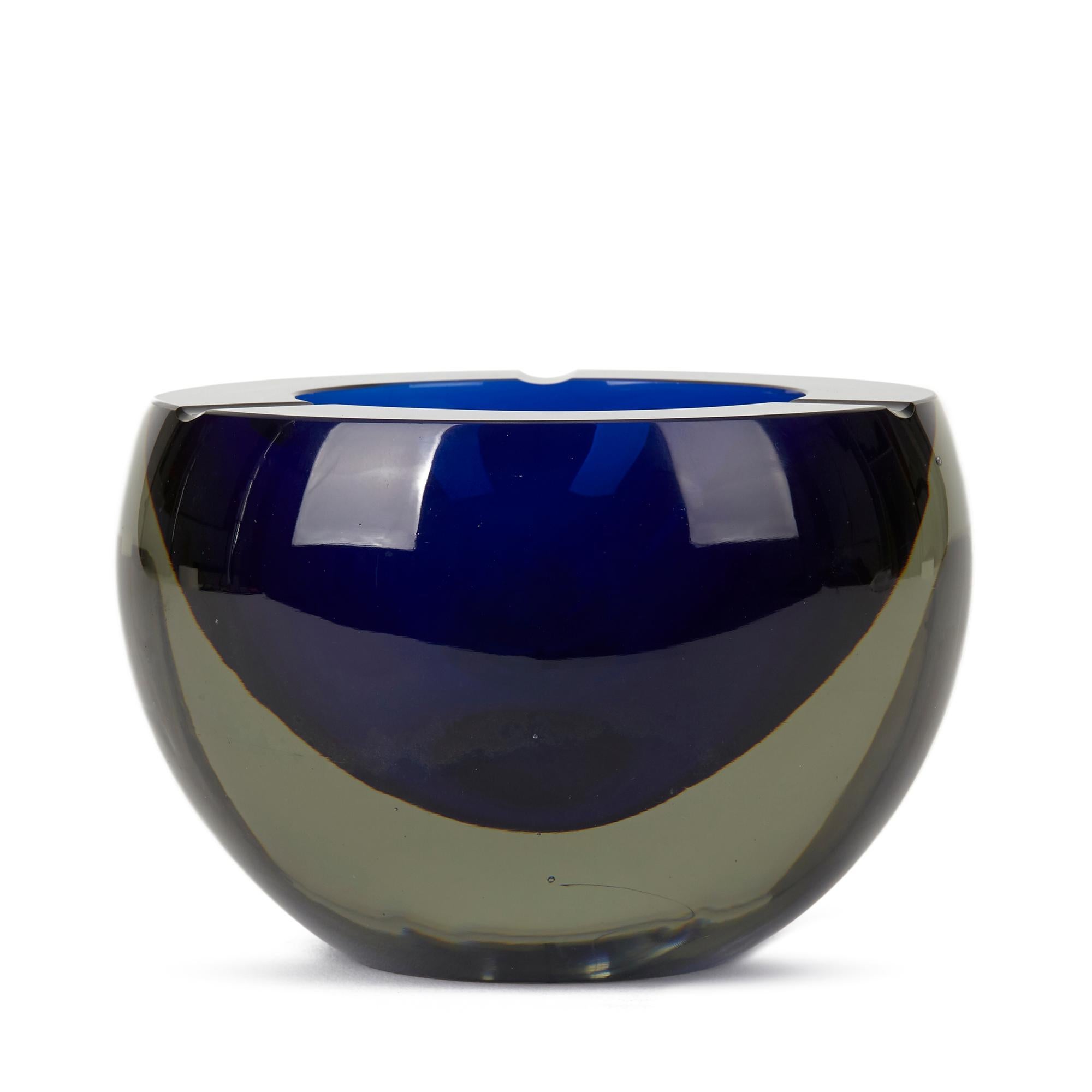 A stylish vintage Italian, Murano Sommerso art glass ashtray of orb shape designed by Antonio da Ros (b.1936) for Gino Cenedese. The heavily made ashtray has a blue centre cased in smoked glass the rounded flat polished opening with a three small