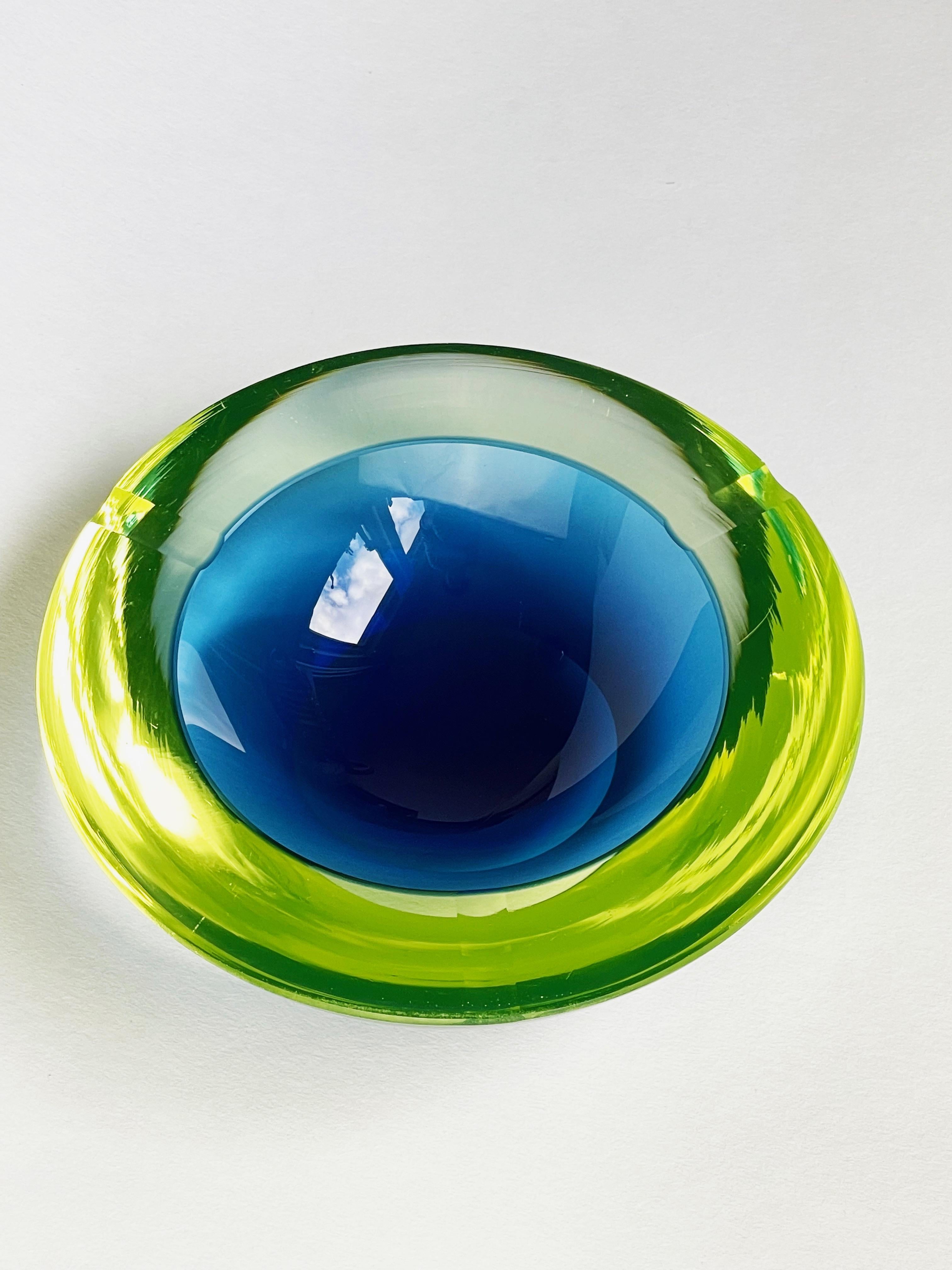 Très impressionnant cendrier en verre de Murano des années 1960-1970 par Cenedese, Italie.
Le jaune verdâtre et chatoyant ressemble à du verre d'uranium et enveloppe le bleu profond de l'intérieur.
Voici une belle pièce de la technique des artistes