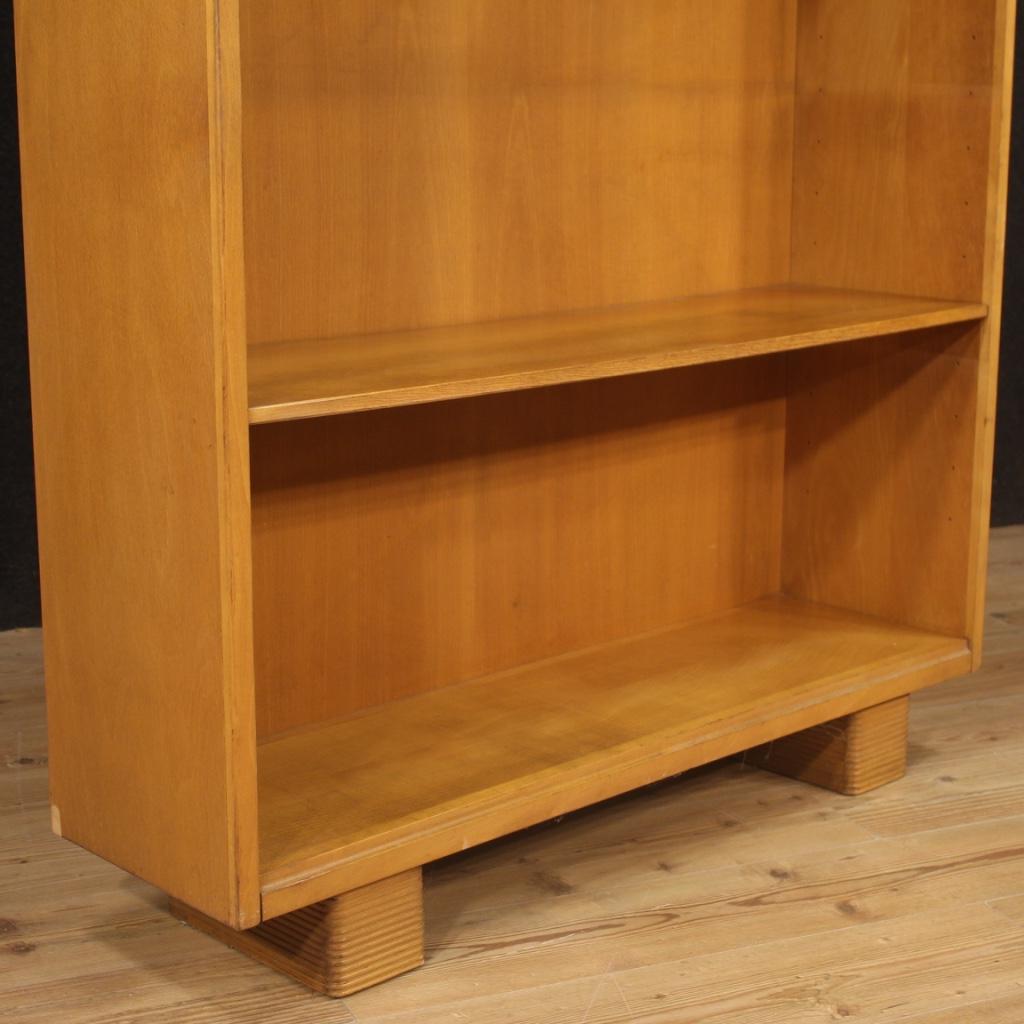 Italian design bookcase from the first half of the 20th century. Furniture carved in beech wood and fruitwood produced by the company Antonio Ferretti of Milan born in 1904. Bookcase equipped with two shelves that can be positioned at various