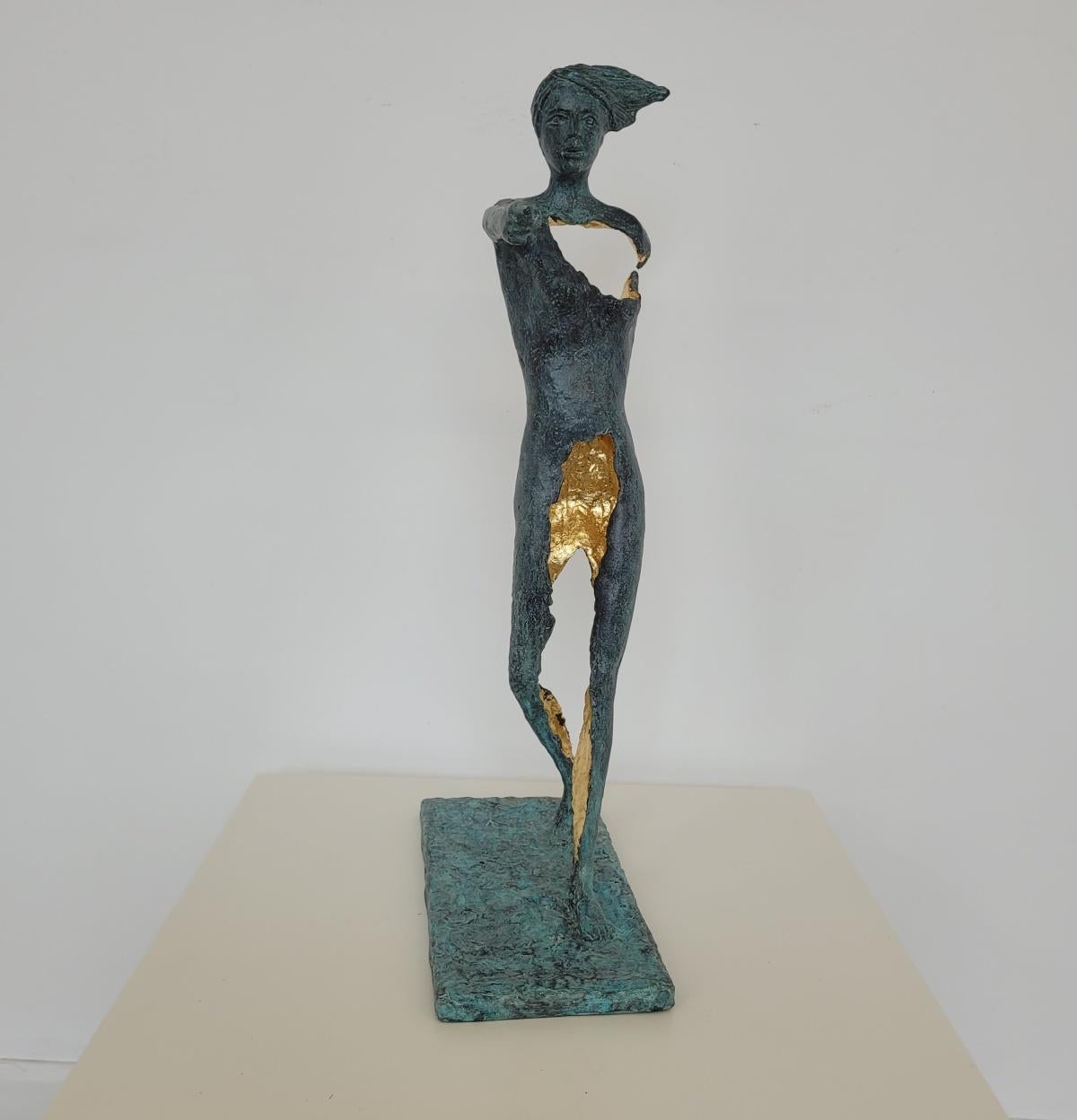 Escultura figurativa contemporánea de bronce patinado del artista italiano Antonio Giancaterino. La escultura muestra una figura femenina durante la marcha, señalando con el dedo en algún lugar de su fuente. Tiene un agujero dorado en el pecho.