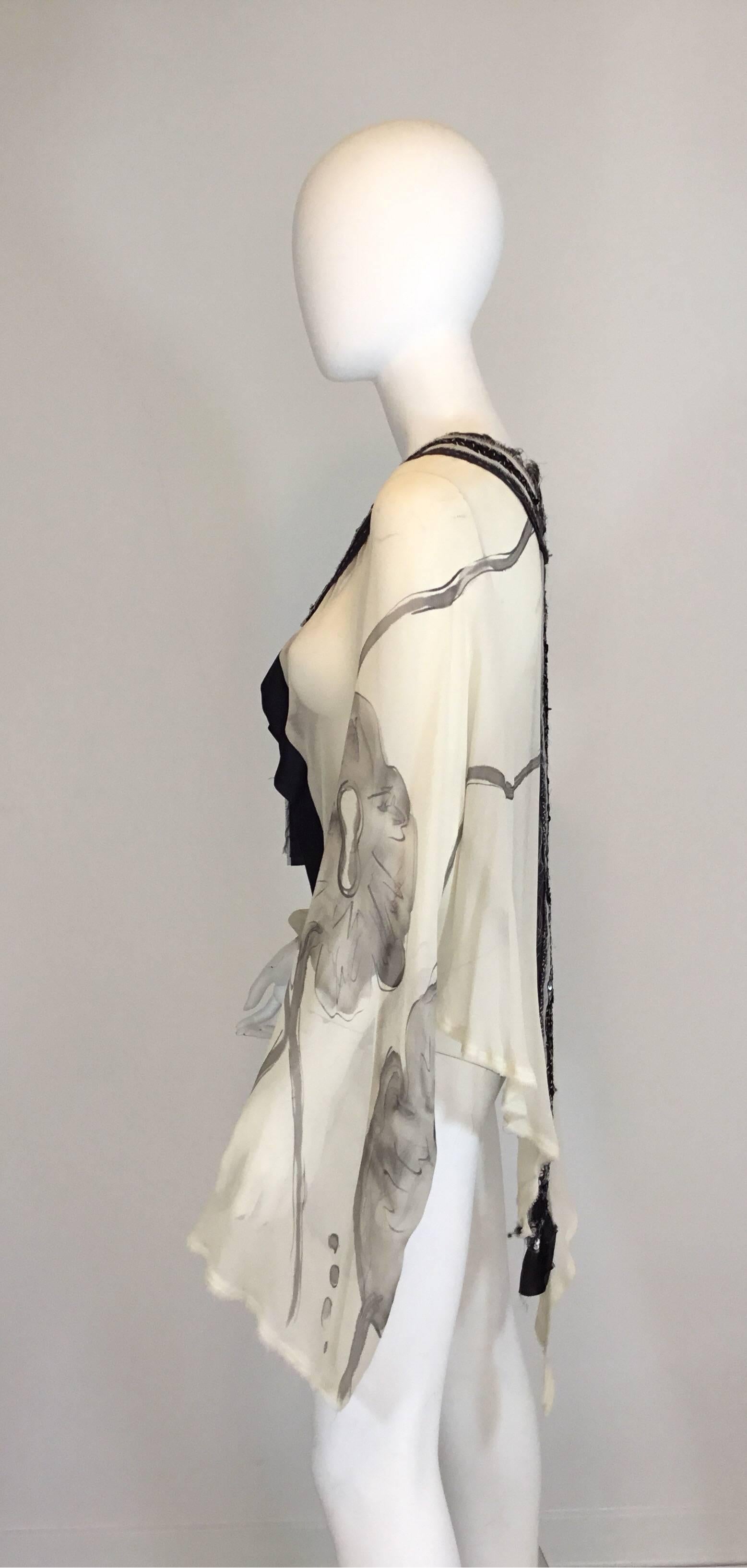 Antonio Marras silk handmade shrug features an embellished trim with sequins and light beading, ribbon tie closure at the neck, hand dyed chiffon and hand stitching. Shrug/shawl is labeled a size 42, 100% silk, and is made in Italy.

Pit to pit-