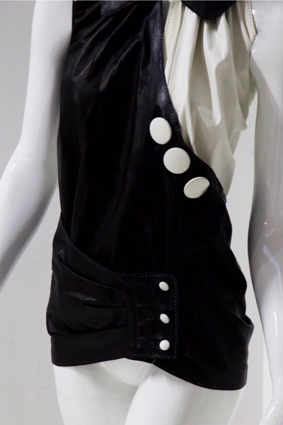 Beautiful white semi-leather and black viscose blouse designed and made by Antonio Marras in the 1980s. The blouse is very particular, in fact it is divided in two by the two main colours: black and white. We see a collar of a blouse that fastens