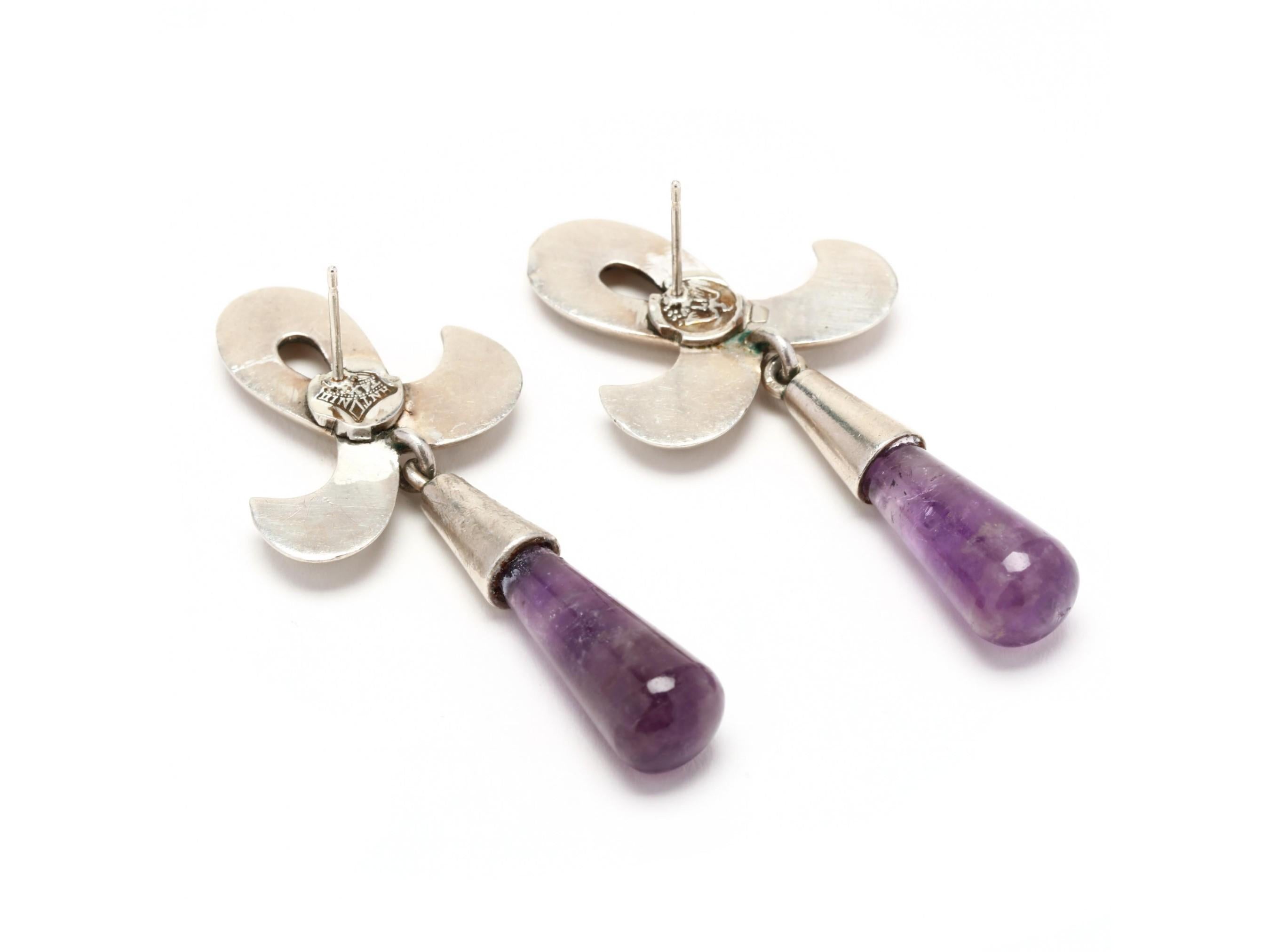 Absolutely beautiful, modernist work of wearable art by Taxco, Mexico master silversmith Antonio Pineda! These circa 1960s earrings have a well-balanced composition of a fleur-de-lis ribbon surmount with elongated teardrop amethyst cabochon dangles