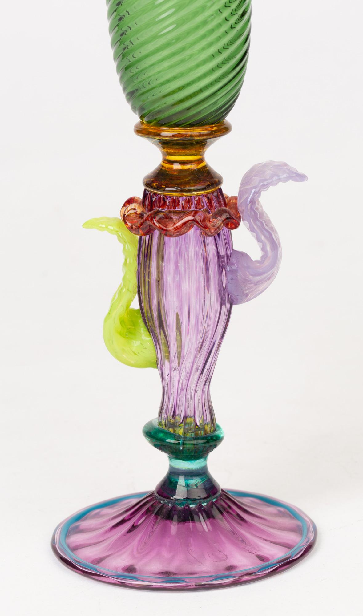 A stunning and elegant Italian Murano Renaissance Revival art glass stem vase designed by Antonio Salviati in the late 19th century. This tall glass vase stands on a wide domed and molded amethyst glass foot with blue piping around the rim with a