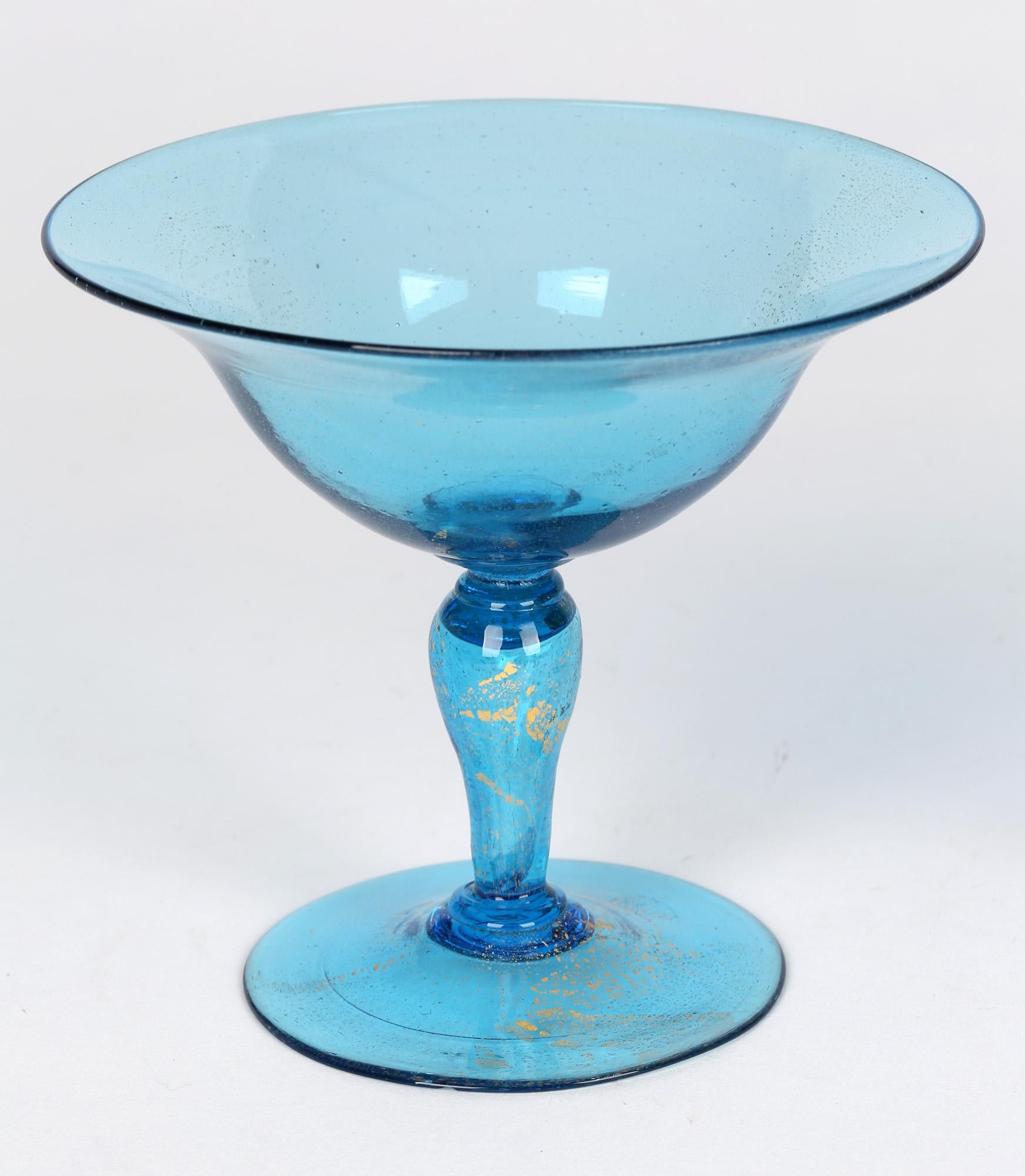 A fine pair of Murano Venetian revival art glass champagne glasses by Antonio Salviati and dating from the early 20th century. The glasses stand on a slightly domed rounded foot with a hollow blown knop stem and with a wide open tapering bowl. The