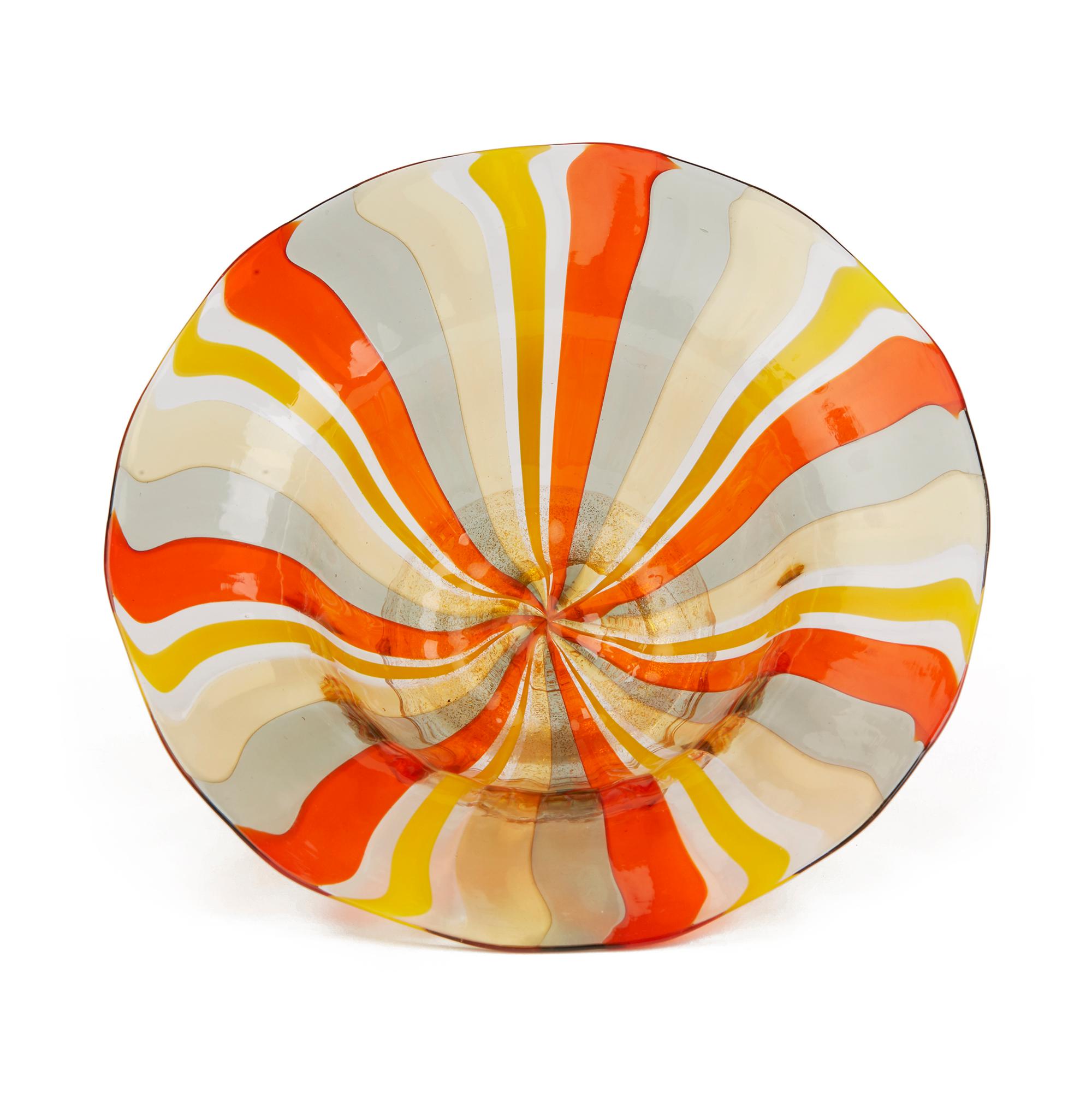 A stunning vintage Venetian Murano Harlequin art glass design bowl by acclaimed glass maker Antonio Salviati. The rounded bowl stands raised on a narrow rounded clear glass foot with gold aventrine inclusions. The slightly irregular shaped bowl