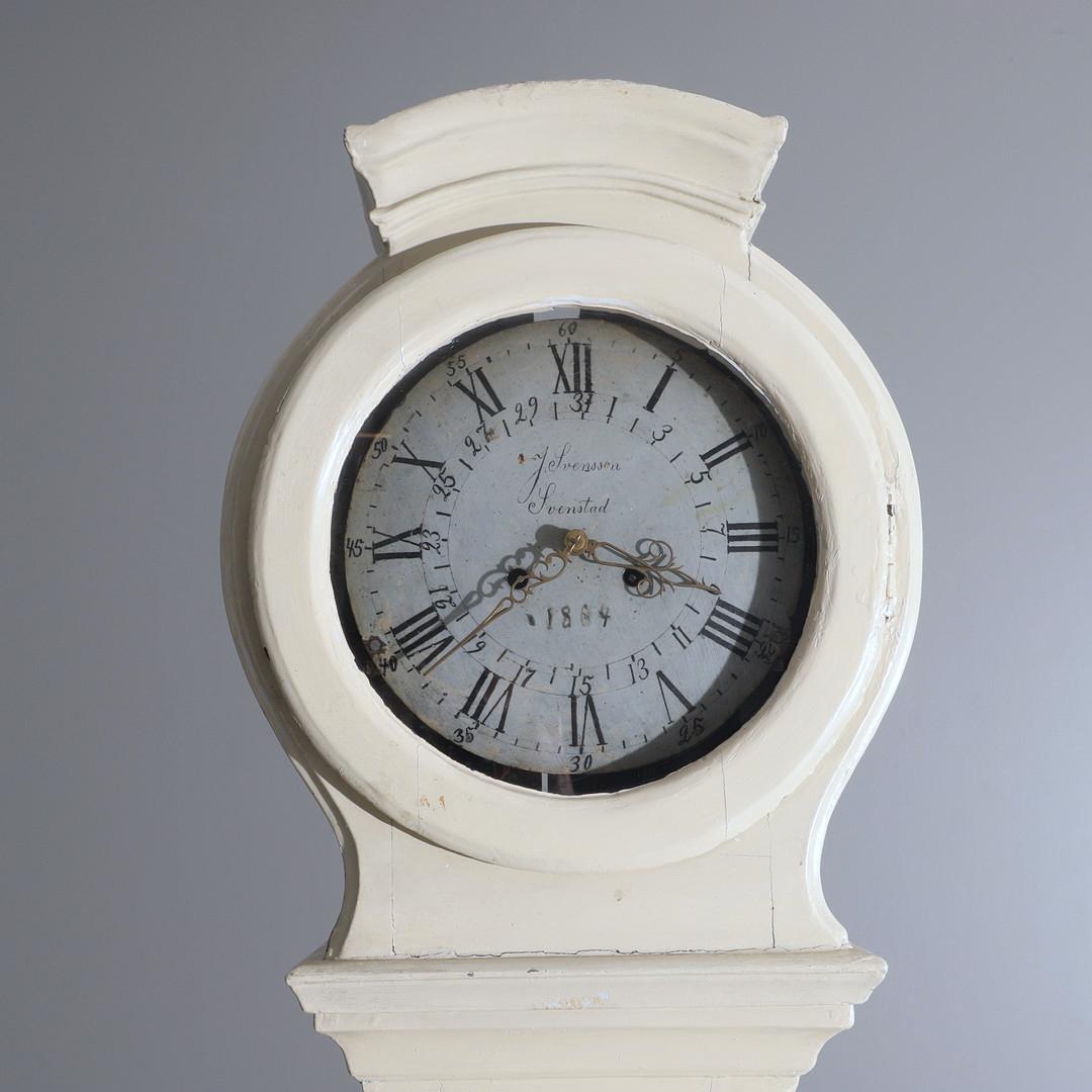 Antique Swedish mora clock from the 1800s in lovely white finish with an unusual shape body and a superb detailed roman numeral face with  makers name J. Svensson Svenstad in good condition. Measures: 209 cm.

It has the Classic extended belly of a