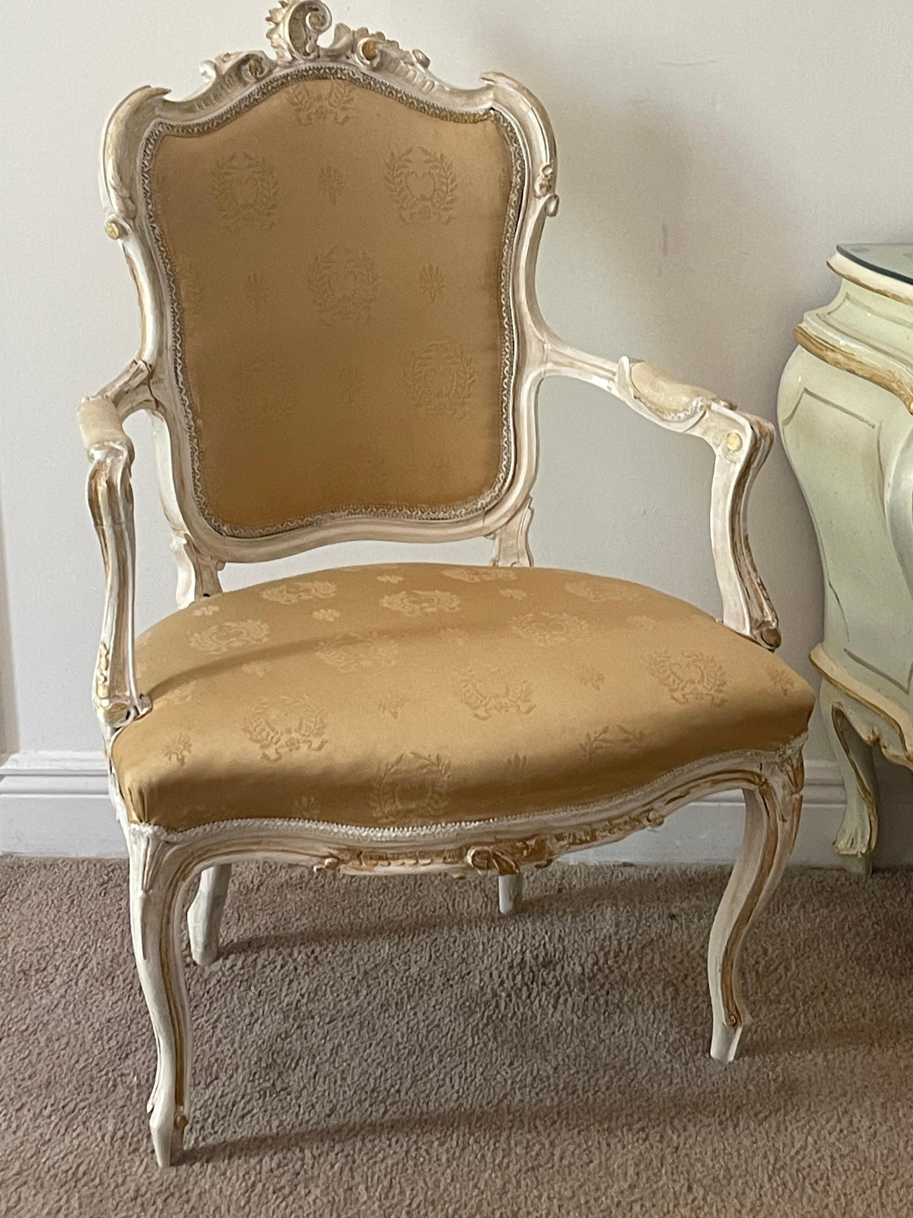 Antica poltrona francese in legno di noce intagliato a mano, in stile Luigi XVI, dipinta di bianco con tocchi d'oro e rifiniture affilate.