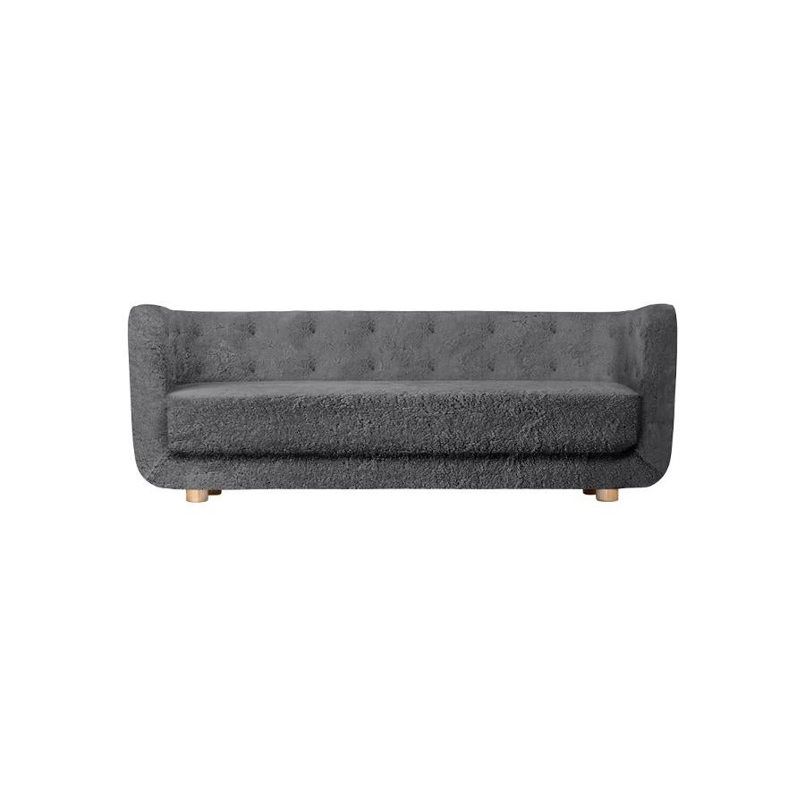 Antrachite sheepskin and natural oak Vilhelm sofa by Lassen
Dimensions: W 217 x D 88 x H 80 cm 
Materials: sheepskin, oak.

Vilhelm is a beautiful padded 3-seater sofa designed by Flemming Lassen in 1935. A sofa must be able to function in