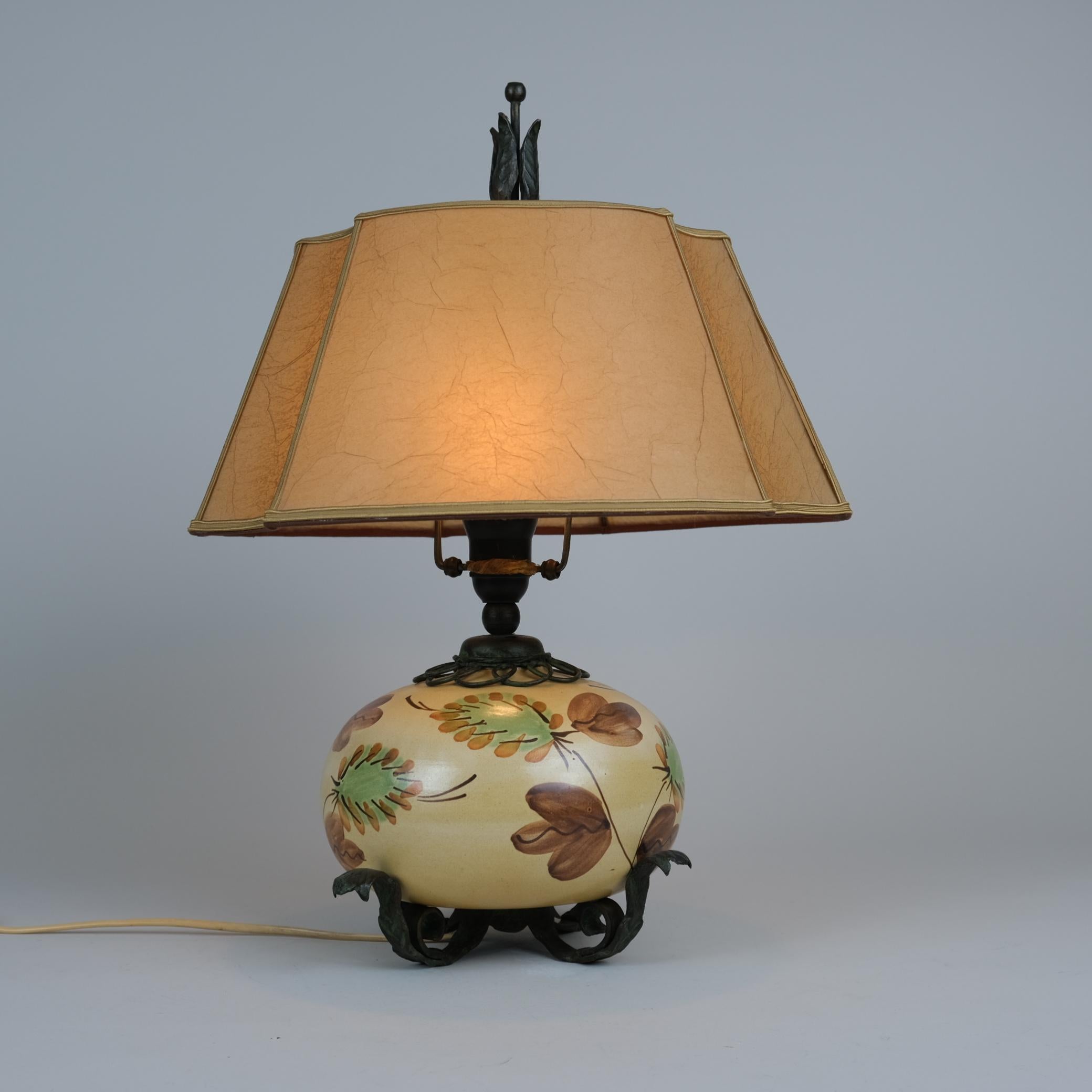 A beautiful table lamp made from wrought iron and ceramic, by Antti Hakkaraien, and manufactured by his company Taidetakomo A. Hakkarainen in the 1930s.
The table lamp is in great original condition with a browinsh/greenish patina on the iron. The