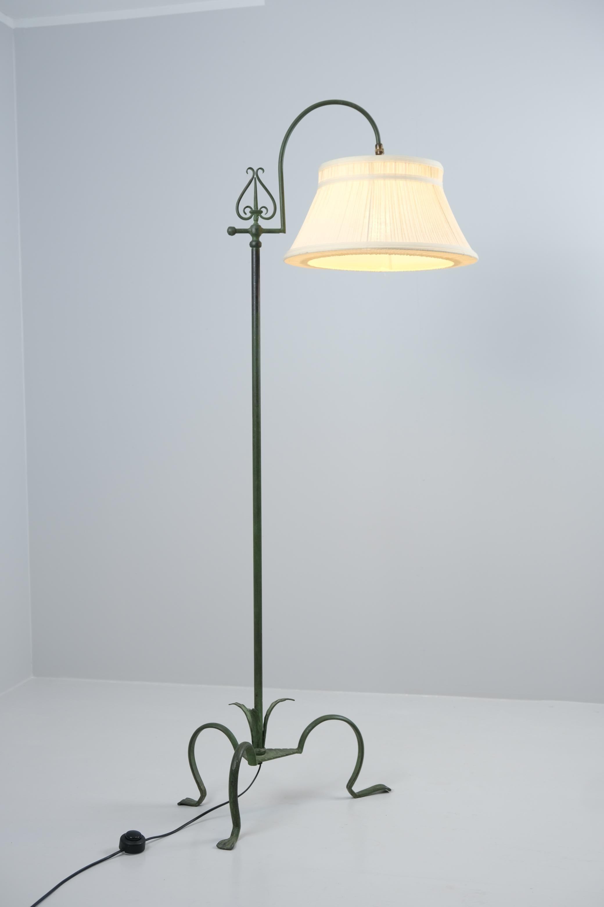 Cette beauté en fer est conçue par le designer finlandais Antti Hakkarainen et fabriquée par Taidetakomo Hakkarainen. Elle possède une structure en fer décorée de motifs de feuilles et d'ornements suspendus, trois pieds courbés et deux sources de