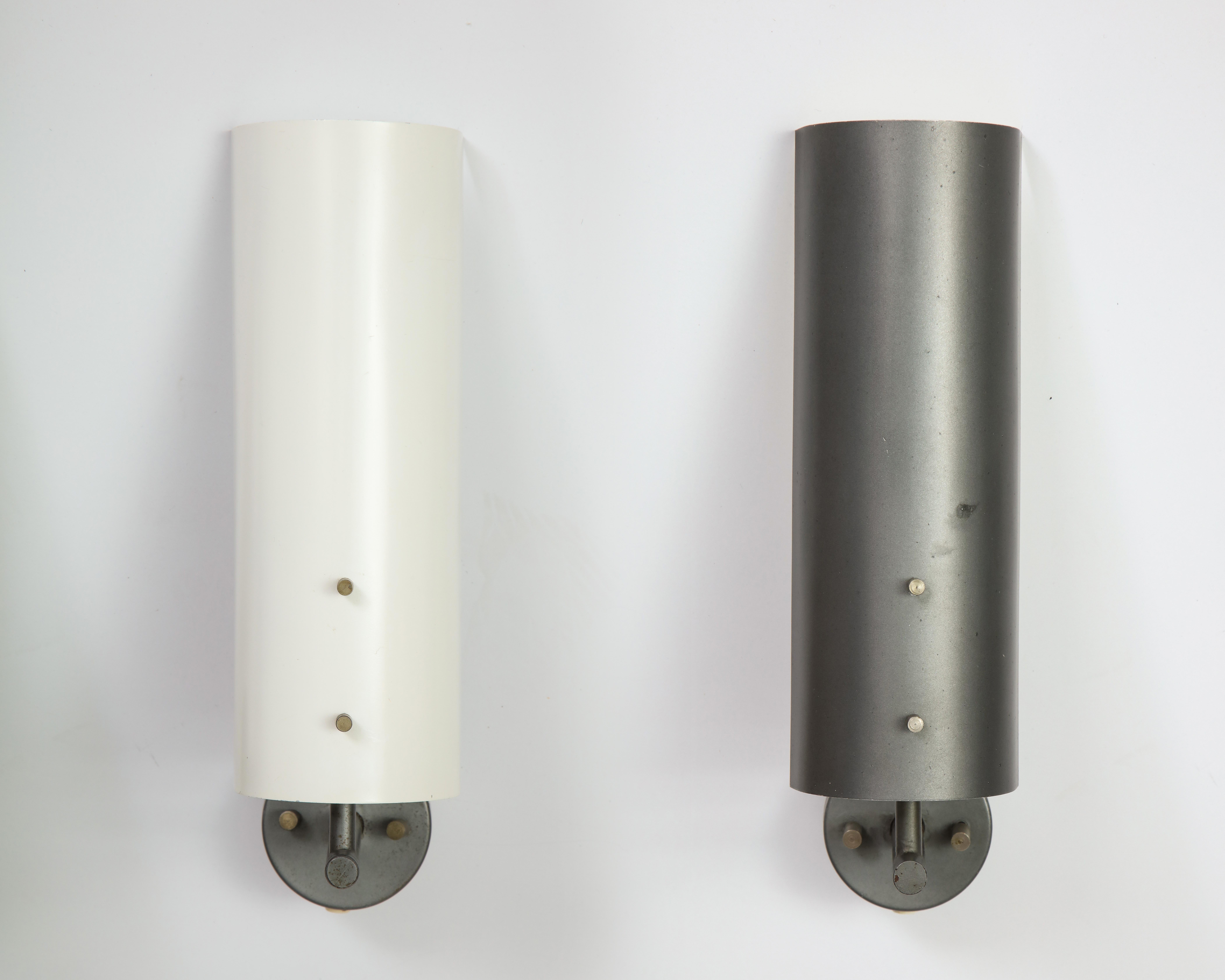 A pair of cold-painted aluminum wall lamps model 7082 designed by J. J. M. Hoogervorst for Anvia Almelo, Holland 1955. These sconces have a grey painted arm; one each of white and dark grey shade. The shade can rotate for a different light beam. The