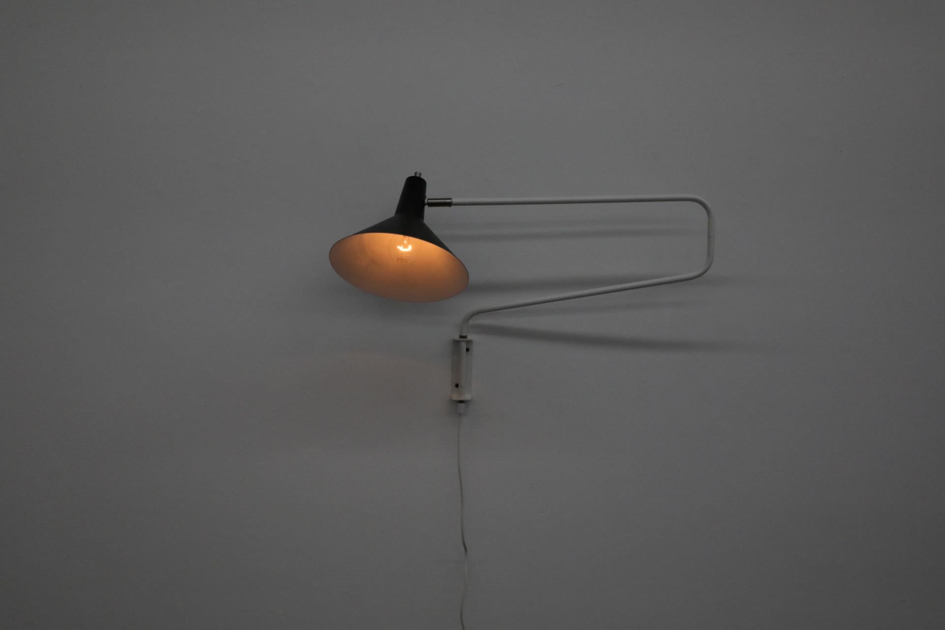 Newly reissued Anvia 'The Paper Clip' wall lamp in black and white. Has paper clip style arm that swings to extend or retract for versatile use and tilting/rotating shade. In the 1950s and 1960s, ANVIA was one of the larger Dutch lighting companies,