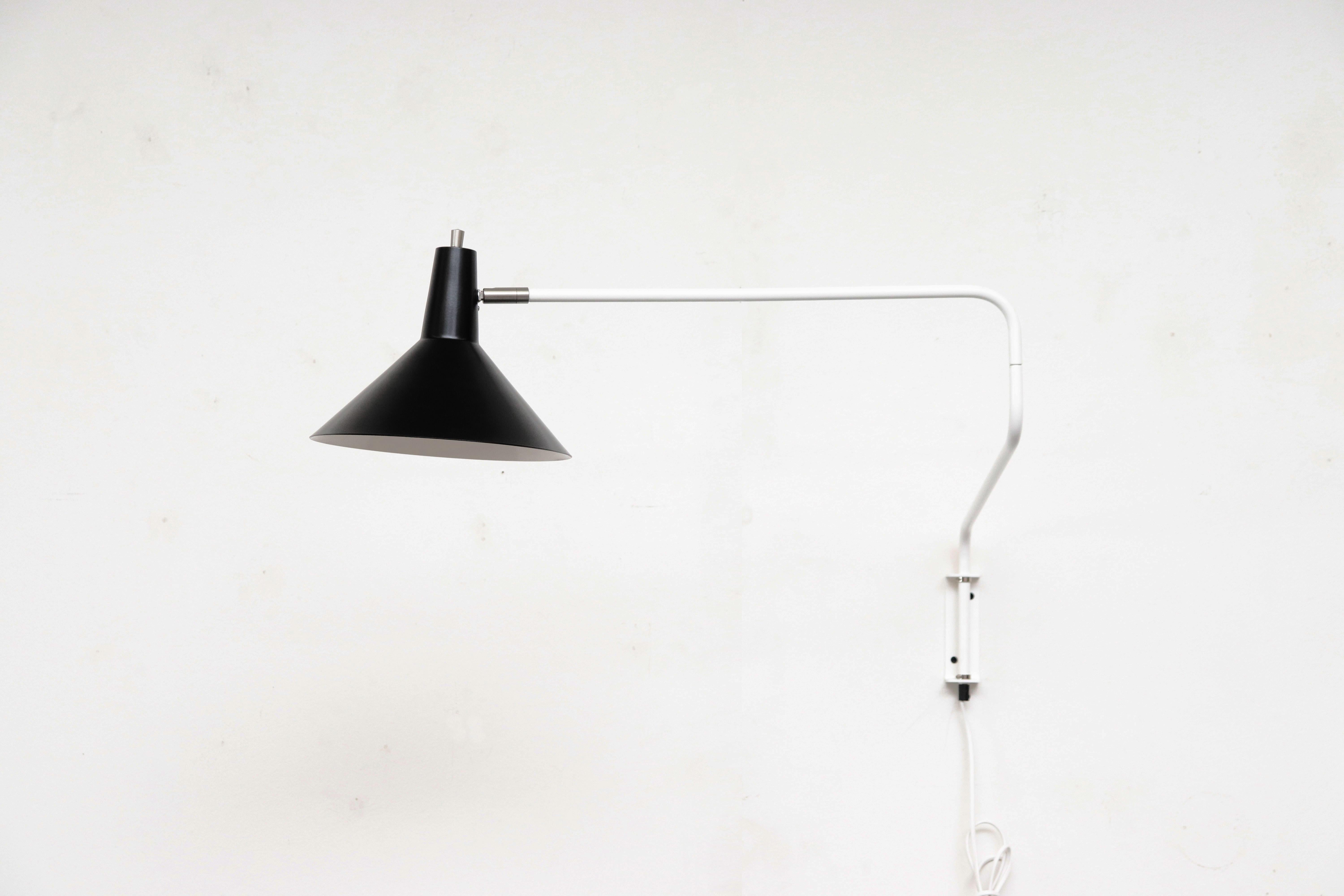 Newly reissued Anvia 'The Paper Clip' wall lamp in black and white. Has paper clip style arm that swings to extend or retract for versatile use and tilting/rotating shade. In the 1950s and 1960s, ANVIA was one of the larger Dutch lighting companies,