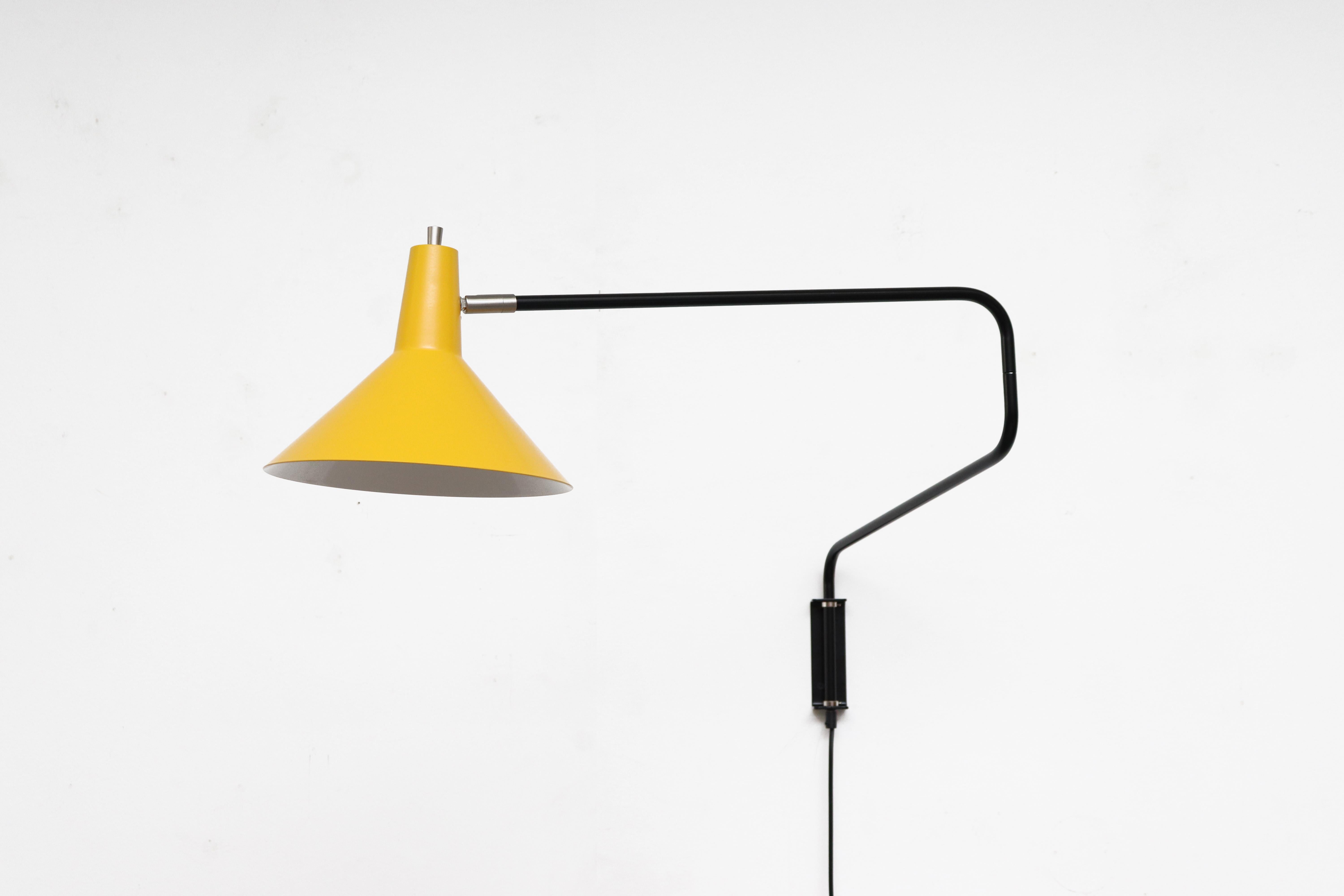 Newly re-issued Anvia 'The Paper Clip' wall lamp in yellow with black frame. Has paper clip style arm that swings to extend or retract for versatile use and tilting/rotating shade. More colors available, listed separately.