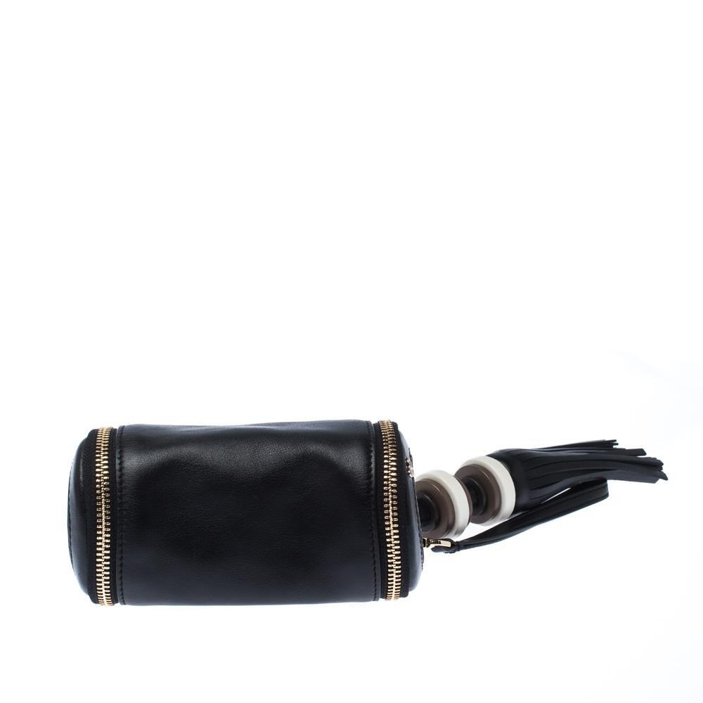 From the house of Anya Hindmarch comes this clutch that is stylish, quirky and eye-catching. It is made from black leather into a cylindrical shape featuring zip closure on either side along with a notable tassel and a wristlet, both detachable.