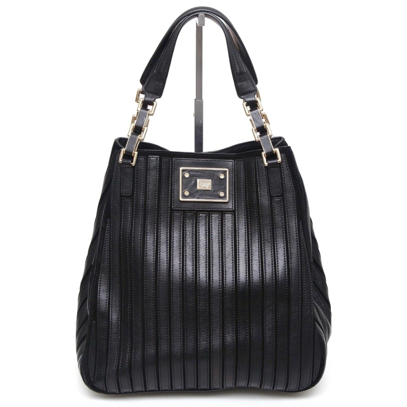 GUARANTEED AUTHENTIC ANYA HINDMARCH BLACK LEATHER SUEDE BELVEDERE SHOULDER BAG

Design: 
- Black leather stripes over black suede background.
- Dual flat handles with gold-tone metal and black hardware accents.
- Detachable black and cream color