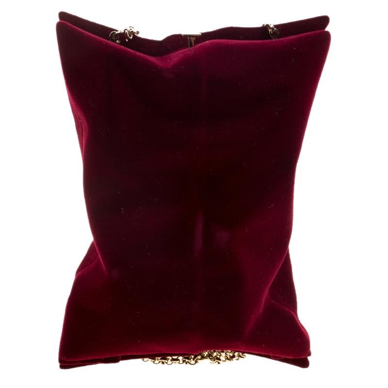 Create the most unforgettable glamorous and special event looks with this stunning Anya Hindmarch Crisp Packet flocked evening bag. Crafted in the most alluring burgundy velvet material, this beautiful bag features a gold tone top clip lock closure