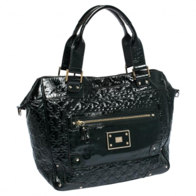 Ce sac 9-to-9 parfait d'Anya Hindmarch se présente dans une teinte vert foncé avec le motif ruban signature brodé sur l'extérieur en cuir verni. Cette beauté est dotée d'une poche frontale zippée, de deux poignées supérieures et d'une bandoulière