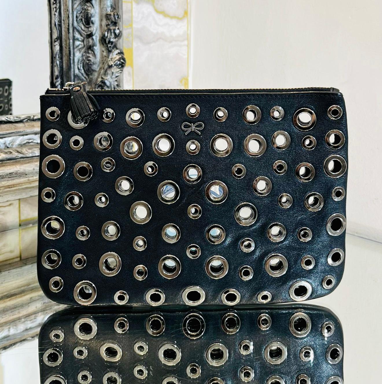 Anya Hindmarch Eyelet Embellished Leather Clutch Bag

Black, envelope-shaped clutch bag designed with peephole detail throughout.

Featuring silver hardware, tassel zipped top and iconic rope bow logo to the front.

Size – Height 16cm, Width 24cm,