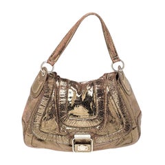 Bolso bandolera Anya Hindmarch de ante laminado dorado con efecto craquelado y hebilla con solapa