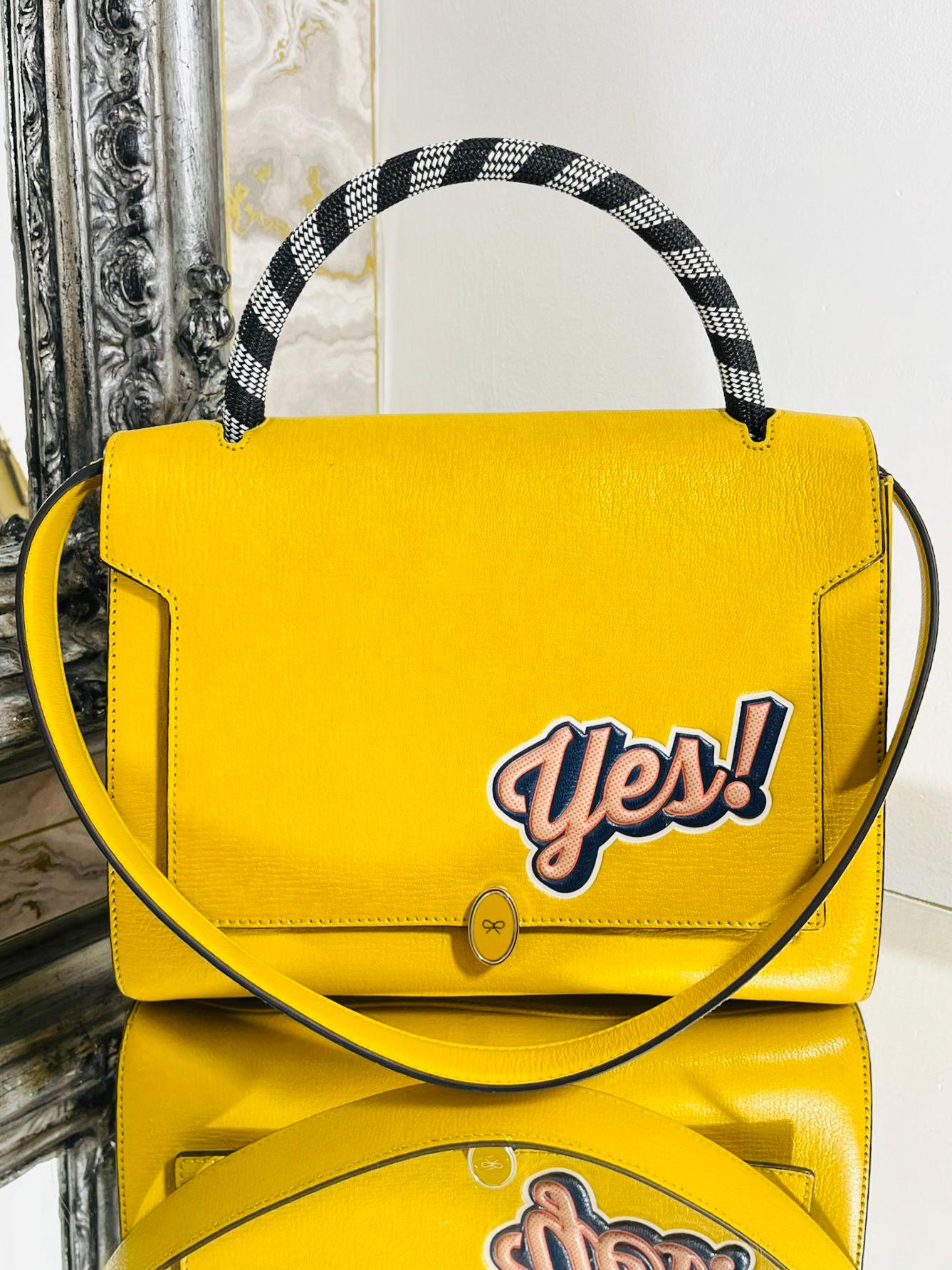 Anya Hindmarch Leather Handbag

Structured bag in yellow with oversized flap adorned with a  enamel logo closure.

Having a 'YES' sticker to the front and a 'NO' sticker to the rear.

Woven black and white top carry handle and removable yellow