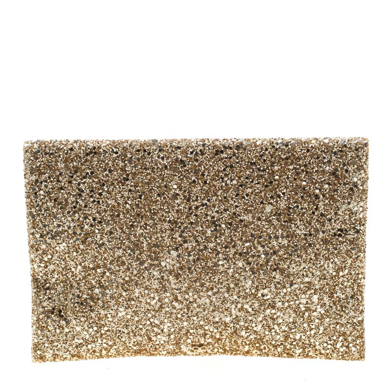 Valorie clutch by Anya Hindmarch is a creation that is not only stylish but also exceptionally well-made. It is a design that is simple and sophisticated. Meticulously crafted from coated fabric and glitter, it flaunts a metallic gold hue and a flap