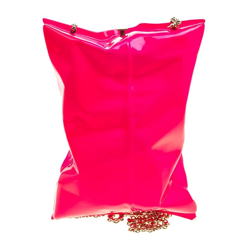 The house of Anya Hindmarch is known for infusing exclusivity in everyday items, and this Crisp Packet clutch is an example of their artistry. This metal-crafted piece comes in neon pink color with a detachable shoulder strap. The clasp closure