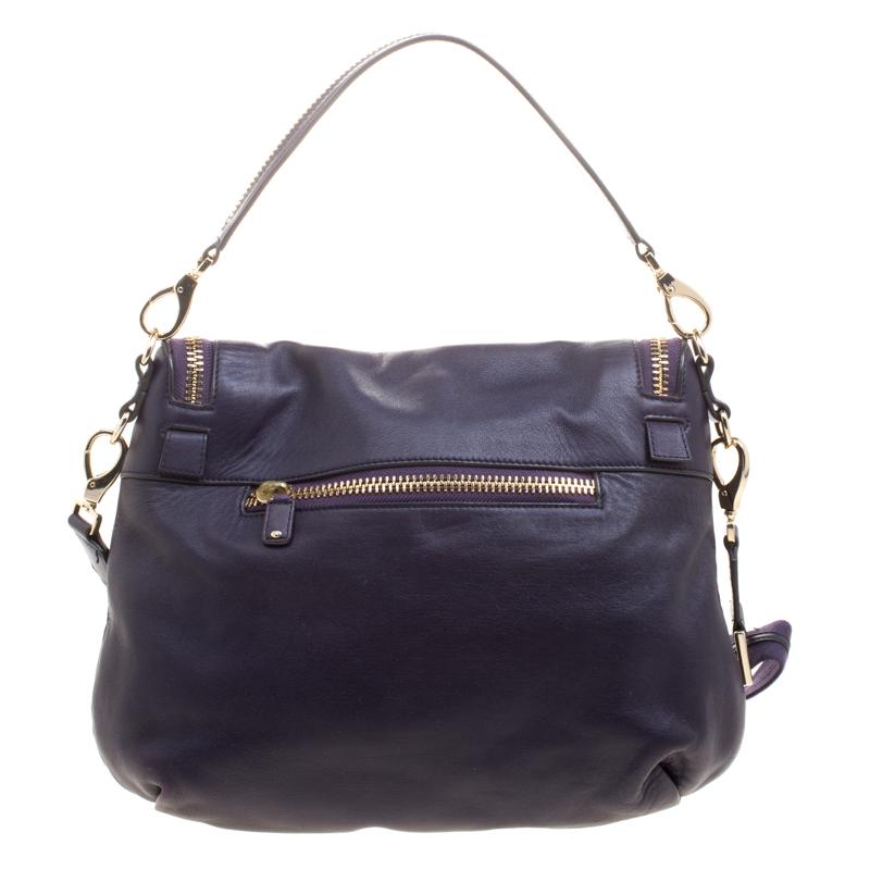 This gorgeous satchel is from Anya Hindmarch. It carries a purple exterior made from leather and it has been equipped with a top handle, a shoulder strap, and a spacious fabric interior. The satchel is ideal for everyday use.

Includes: Original