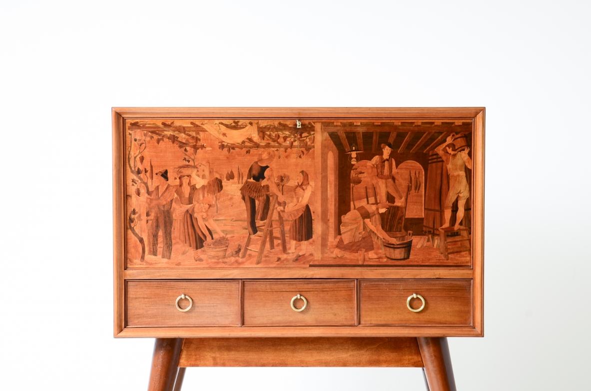 COD-2522
Anzani & C

Extraordinary bar cabinet with inlaid front depicting harvest scenes and turned legs with brass tips. Refined interiors in flamed maple with shelves, mirrors and three drawers.

Signature of the design, Carlo Corvi, execution of